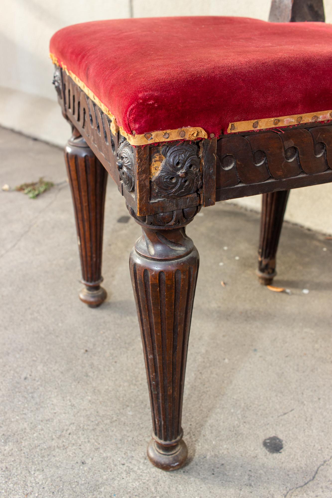 This antique French dining chair is crafted in oak with a red velvet upholstered seat. The curves of the back are wonderful and this piece also has unique carved rosettes and geometric details around the seat edge. The edge of the seat has exposed