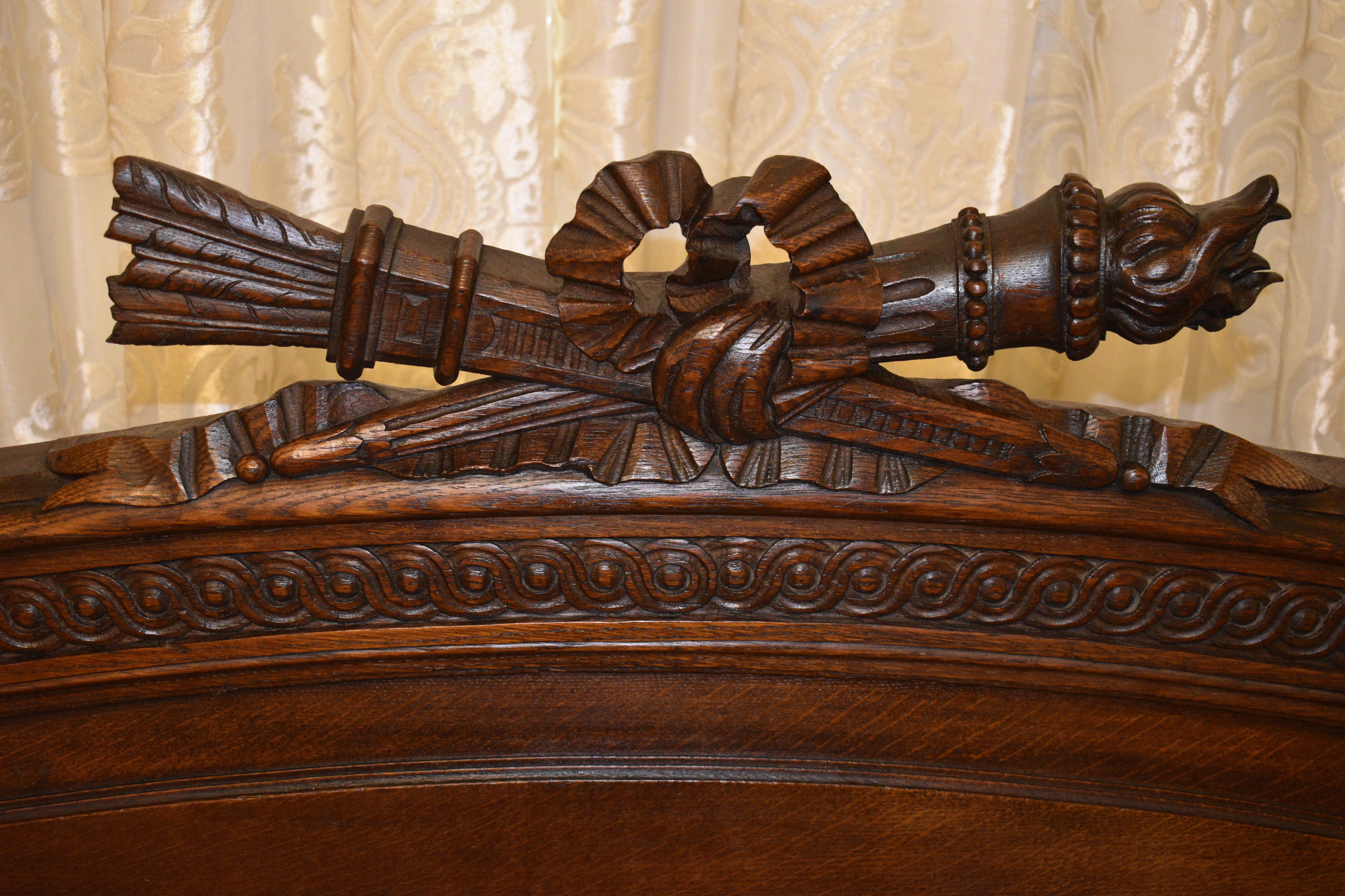 Arrows in quill and a torch tied with carved timber bow to the head board. Four large finials to the corners and a carved design repeated on the foot of the bed. Comes with slats

Circa: 1870

Material: French Oak

Country of Origin: