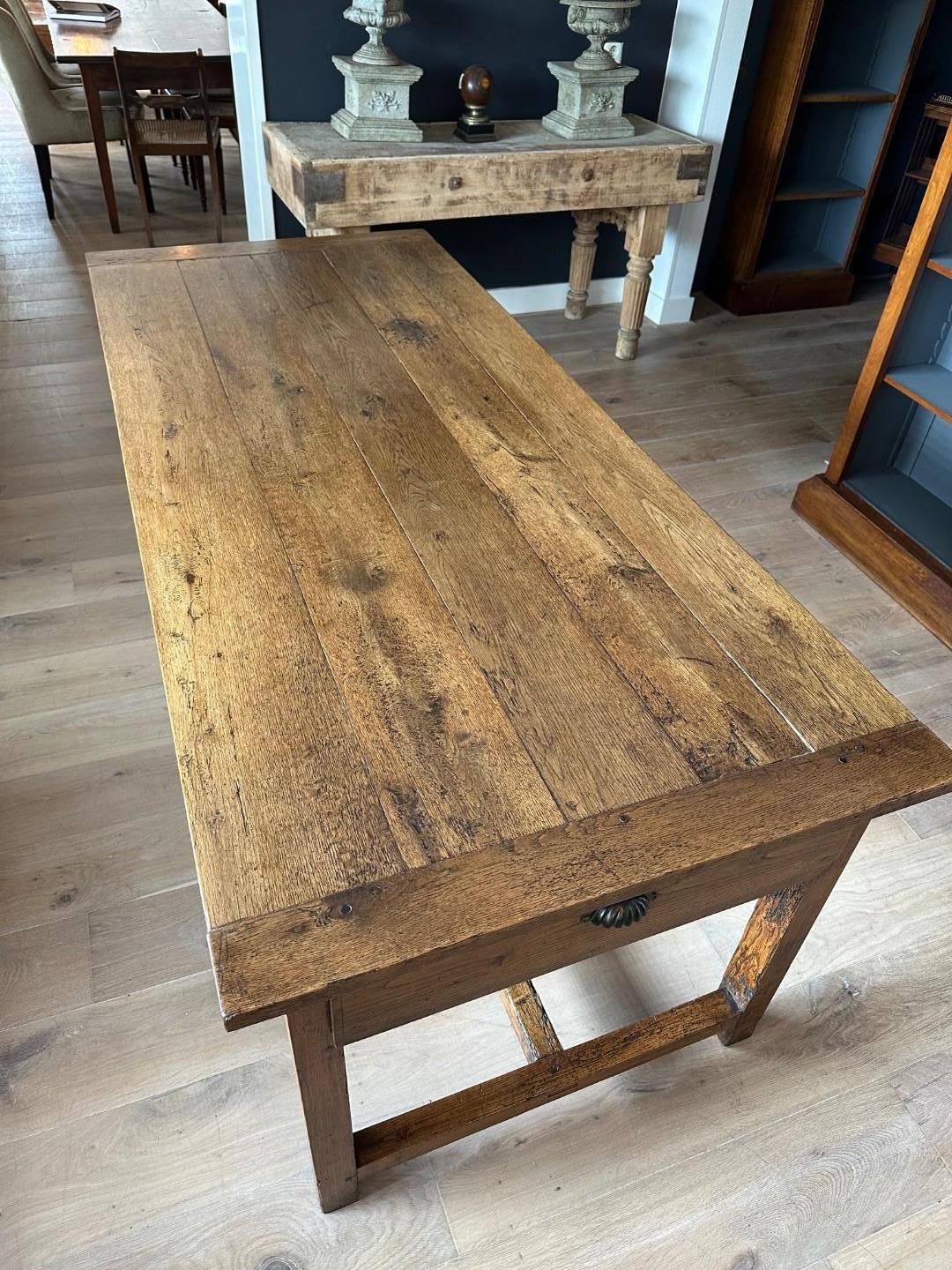 Beautiful antique French oak table with two drawers. In perfect condition. Superb patina. The two drawers at the end edges have been made shallower for more legroom. However, the front has been preserved for aesthetic appeal. The table has signs of