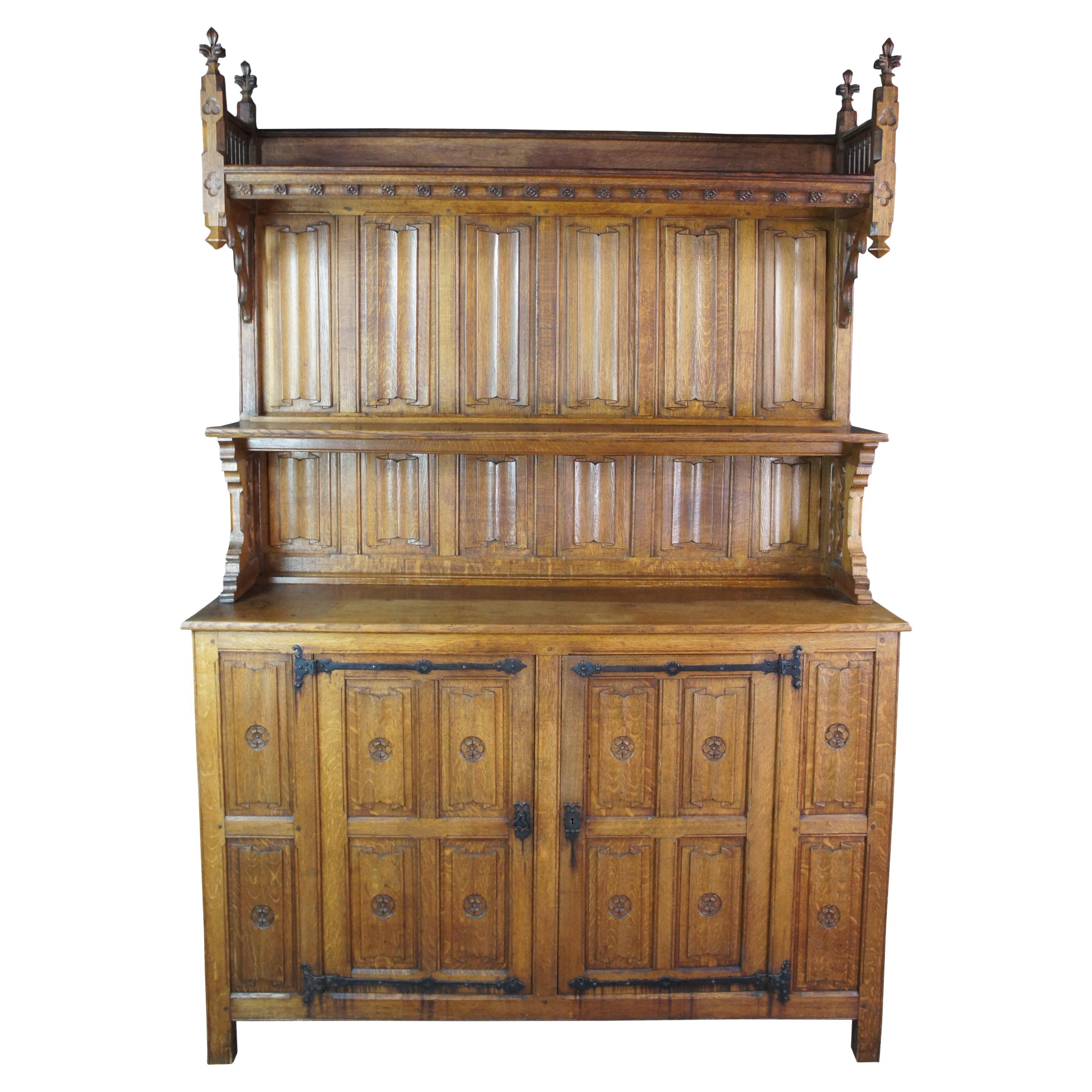 Monumental antique French Gothic Revival Vaisselier, bar back, server, buffet, sideboard or cupboard. Made of oak featuring paneled linen fold designs with fleur de lis finials, reticulated fretwork, plate grooves and hammered iron