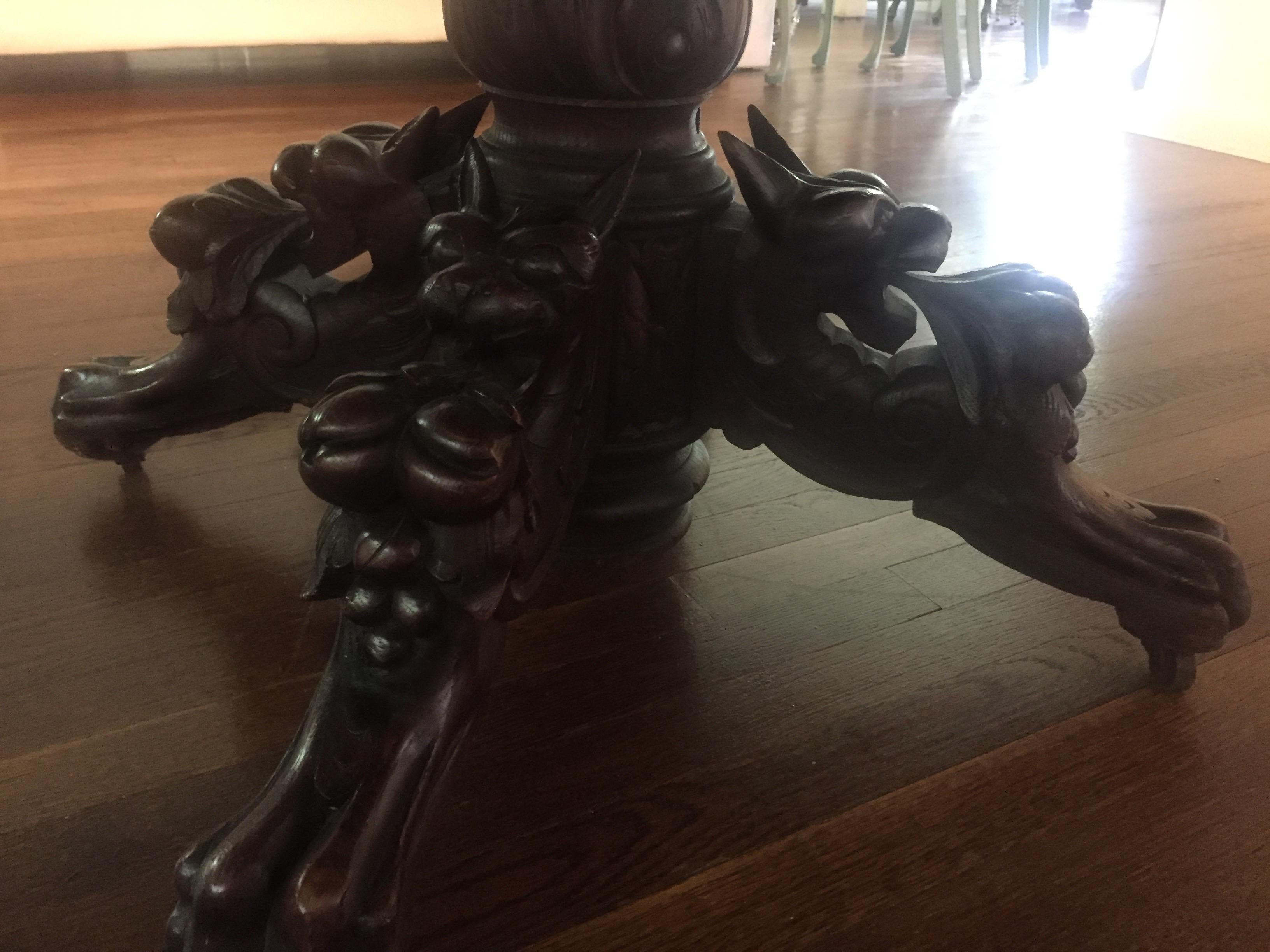 Antique French oak hunting pedestal dining table, extendable, 19th century. Includes a finished, matching pair of leaves. This table is supported by a large, center pedestal with hand carved with griffens, fruit and foliage, four scrolled feet and