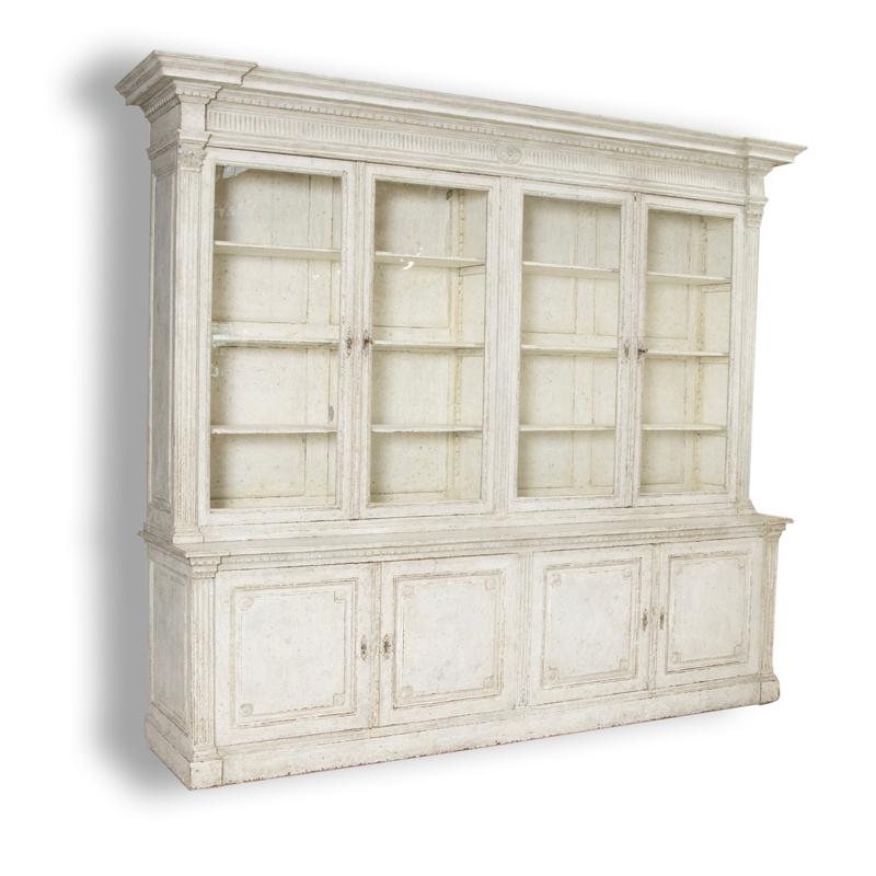 French country large display cabinet, bookcase or vitrine in two sections.
Oak wood later professional painted in layers of white and soft grey with wonderful distressed finish.
Upper section with cornice featuring carved dentil molding,