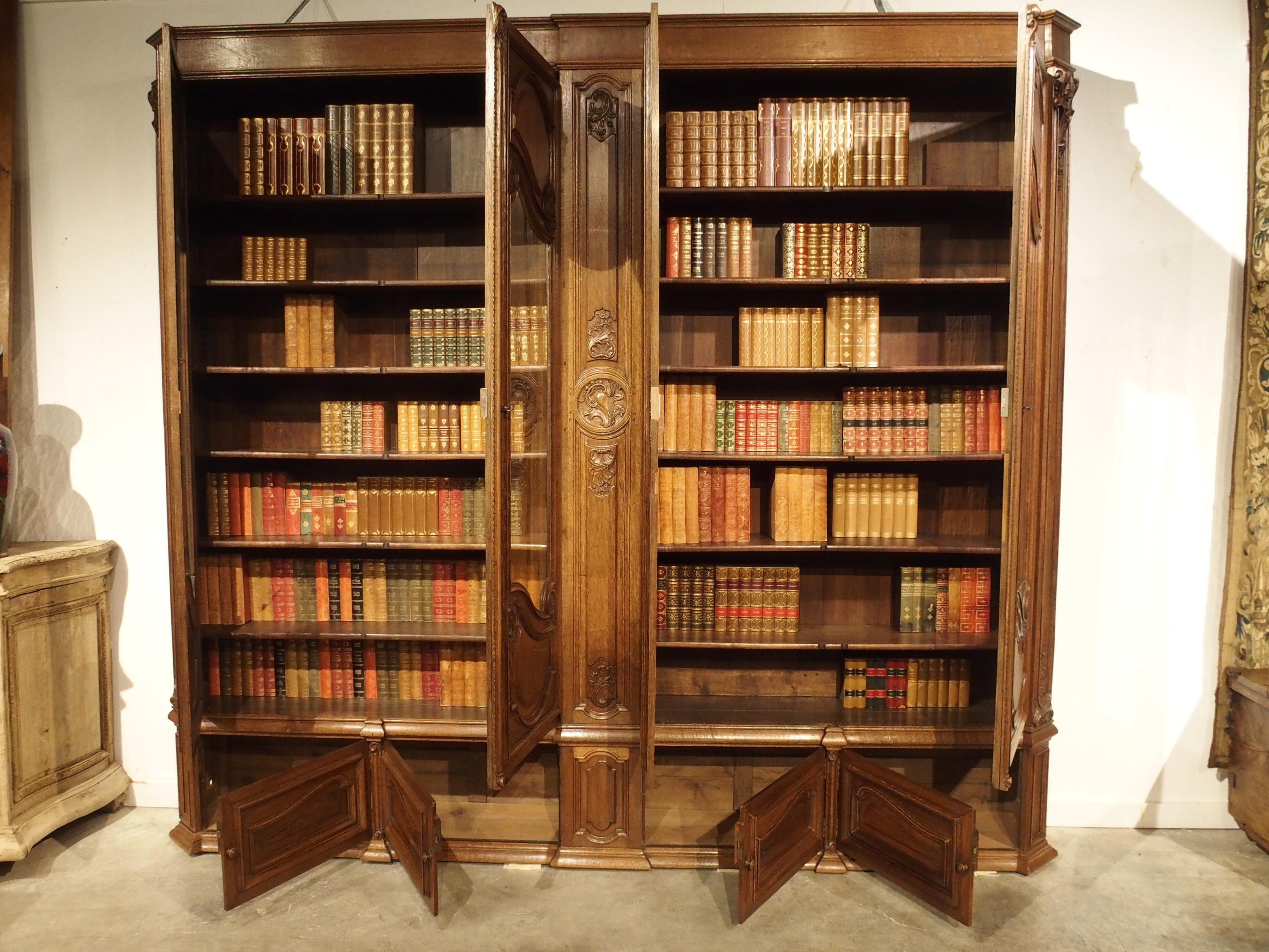 This fabulous antique French oak double bibliotheque recently came from an Estate in Nice, France. Although it has a large width of just over 10 feet, it has a very shallow depth of only 16 inches. This is not common in antique case pieces. The