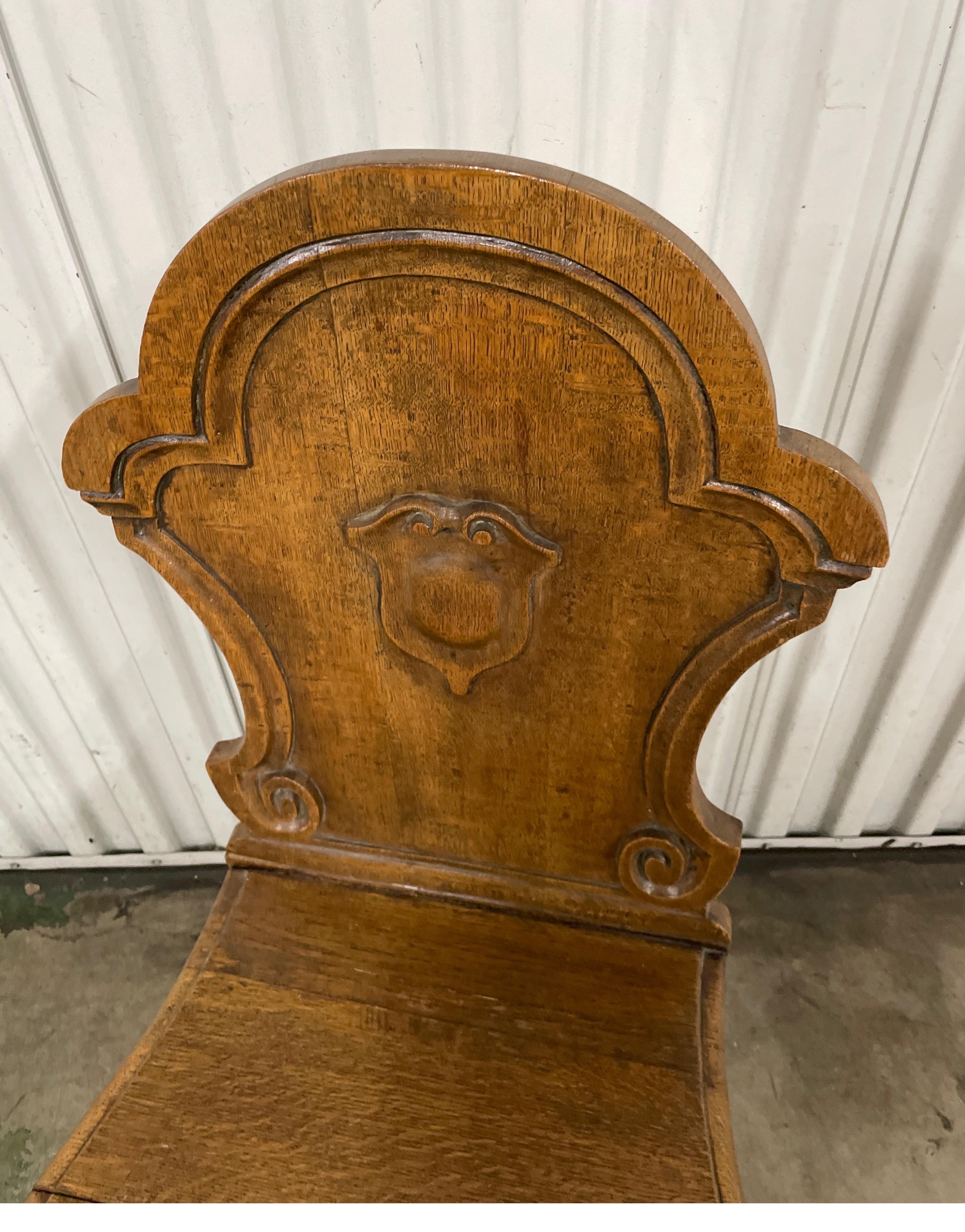 Unusual single carved oak side chair featuring a cartouche detail on the upper back. The two front legs are in the cabriole style. A very unique piece.