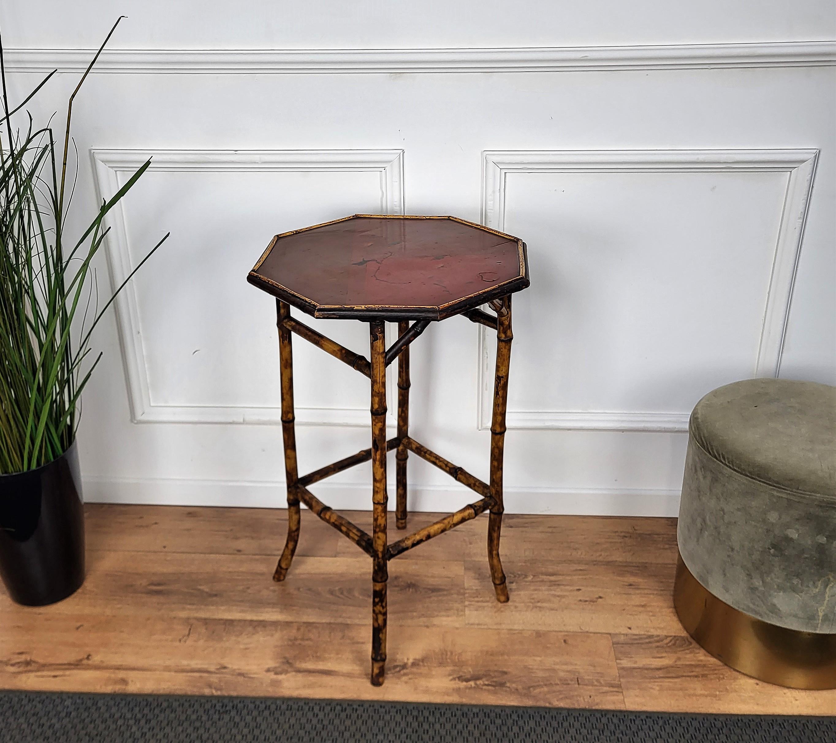 Beautiful antique French bamboo side table, with flared legs and an unusual octagonal top accented with a red chinoiserie lacquered top. The bamboo, vividly painted, is in good sturdy condition. The feet are splayed for a more elegant look and feel.