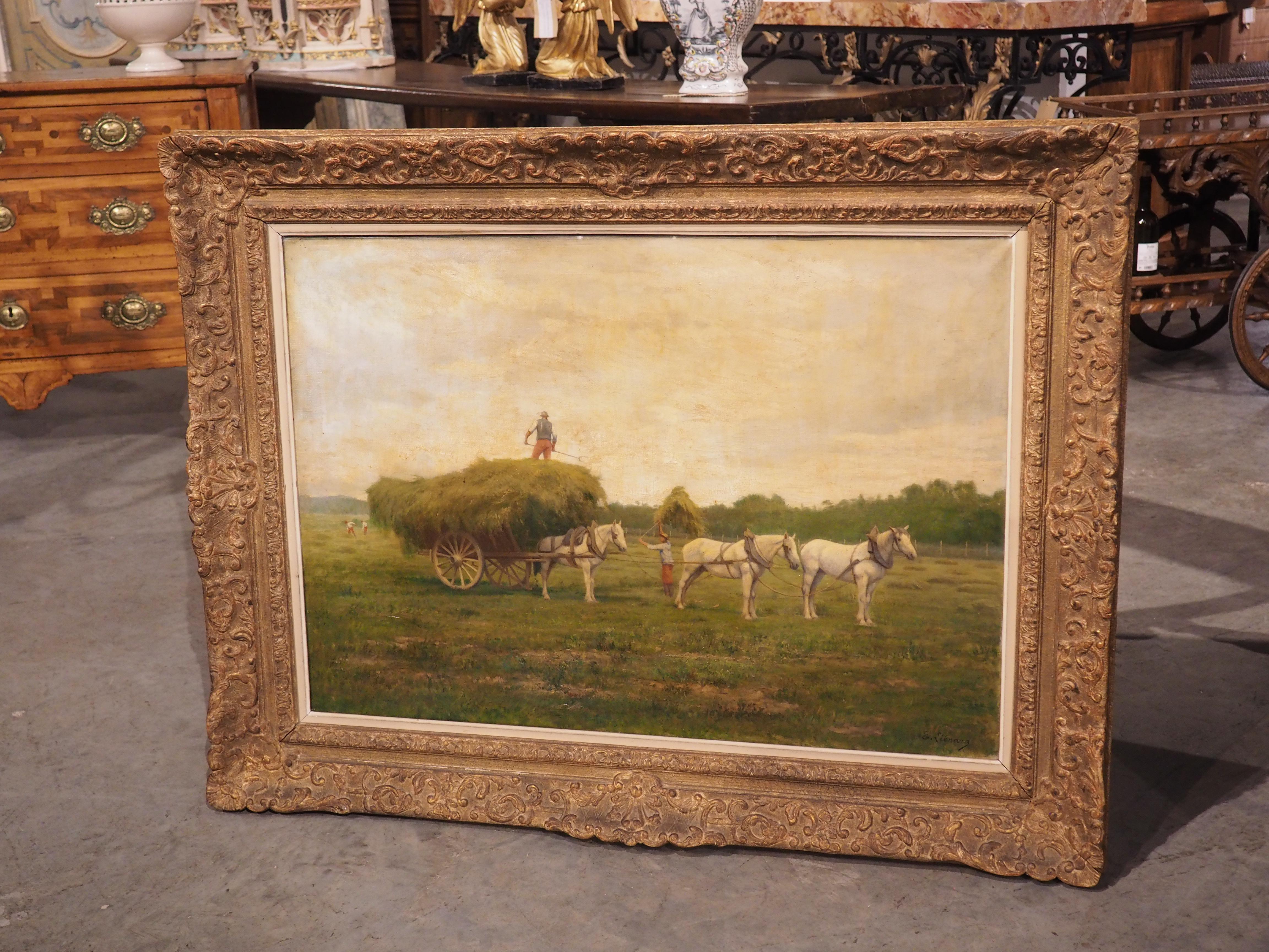 Presented in a foliate-themed giltwood frame, this oil painting captures the essence of a French farm in the 1800s. A lush green landscape beneath a sky filled with fluffy white clouds serves as the perfect backdrop for the focal point of the piece.