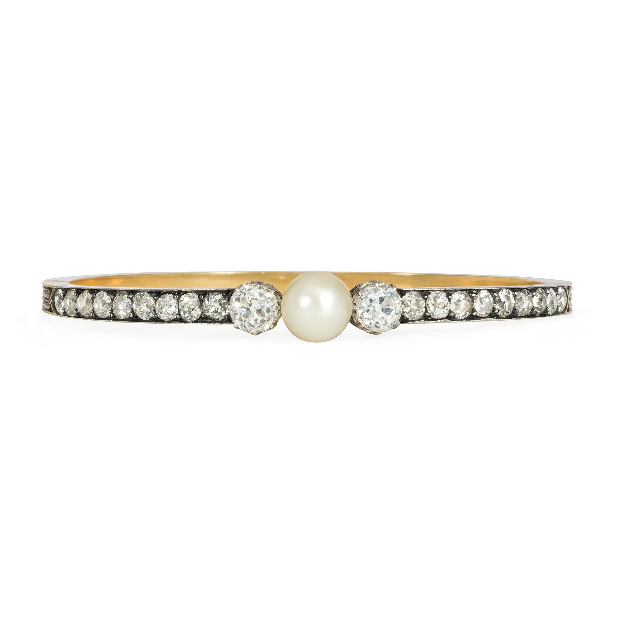 An antique Victorian period gold, diamond, and pearl hinged bangle bracelet, the top set with a row of old mine-cut diamonds and centering on a pearl flanked by two old European-cut diamonds, in sterling silver and 18k.  France.  Atw 3.23 cts.