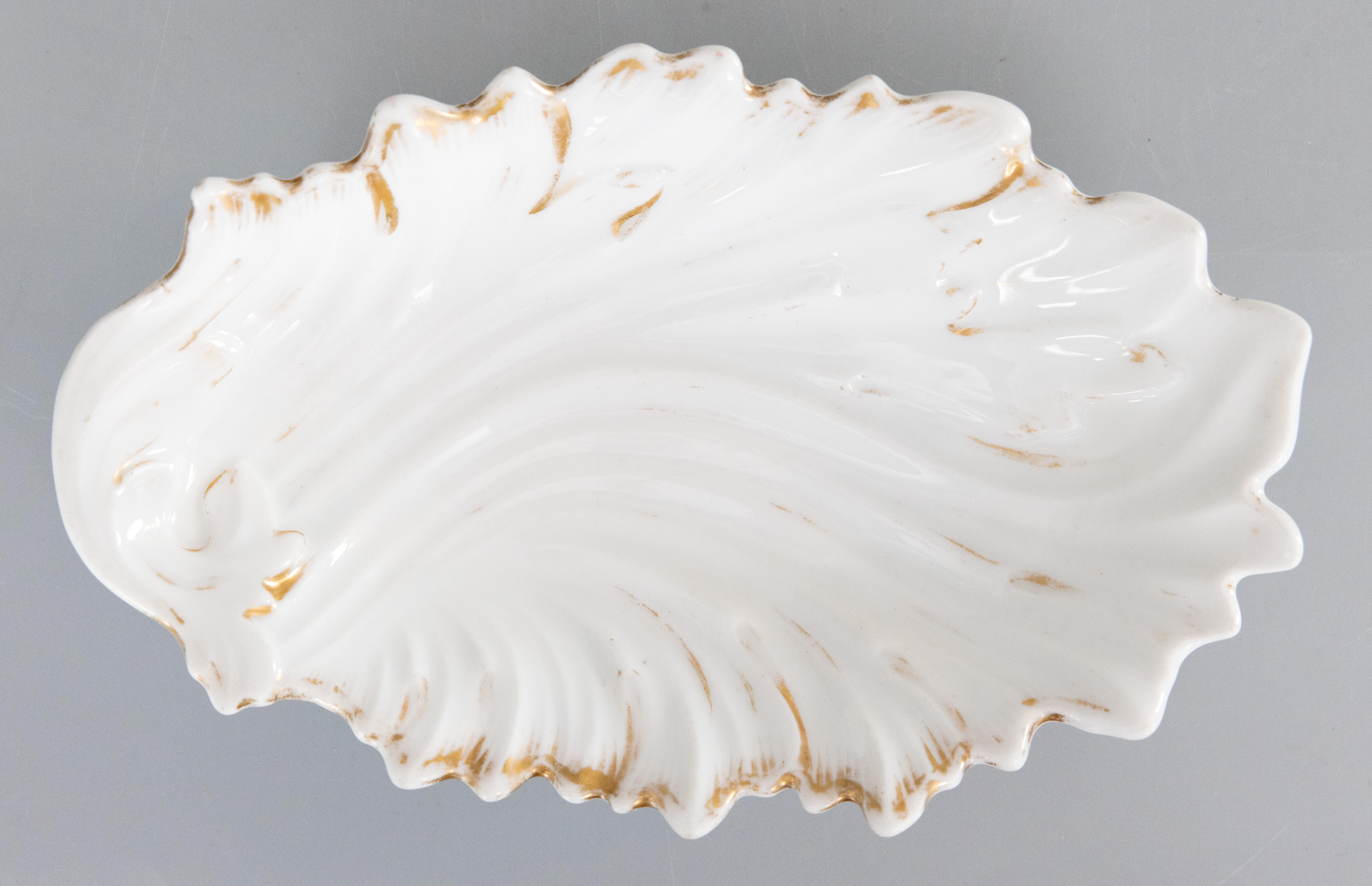 A lovely antique French Old Paris porcelain dish, bowl, or Vide-Poche catchall. This beautiful dish has scalloped edges, a scrolling leaf design, and gilt details, perfect on a dresser for jewelry, or as a catchall dish, or could also be used for