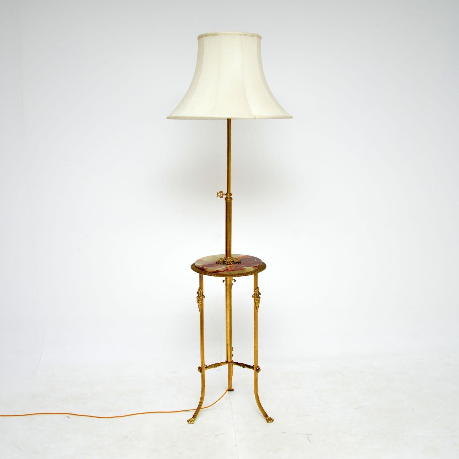 A beautiful and extremely well made antique floor lamp with a built in table. This was made in France, it dates from around the 1920’s.

The quality is superb, the brass has amazing details, and the lamp has a rise and fall mechanism. The table