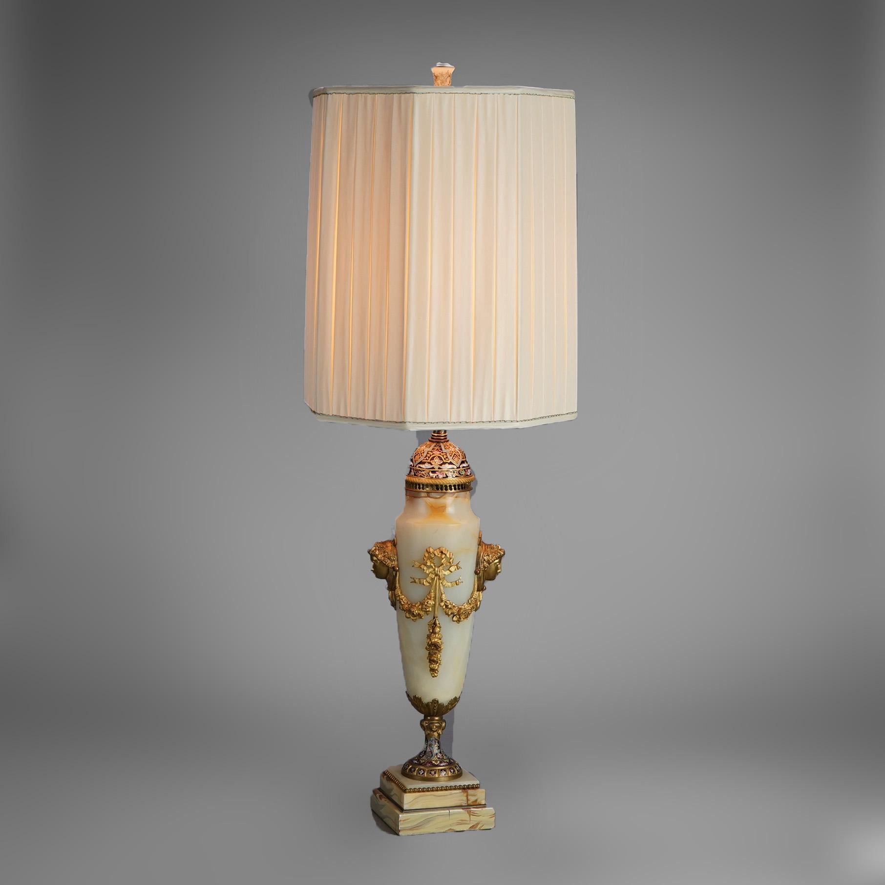 An antique French table lamp offers onyx urn form bodice having Neoclassical cast ormolu foliate and female mask mounts, raised on champleve enameled base, wired for US electricity, c1920

Measures- 36.5''H x 11.5''W x 11.5''D
