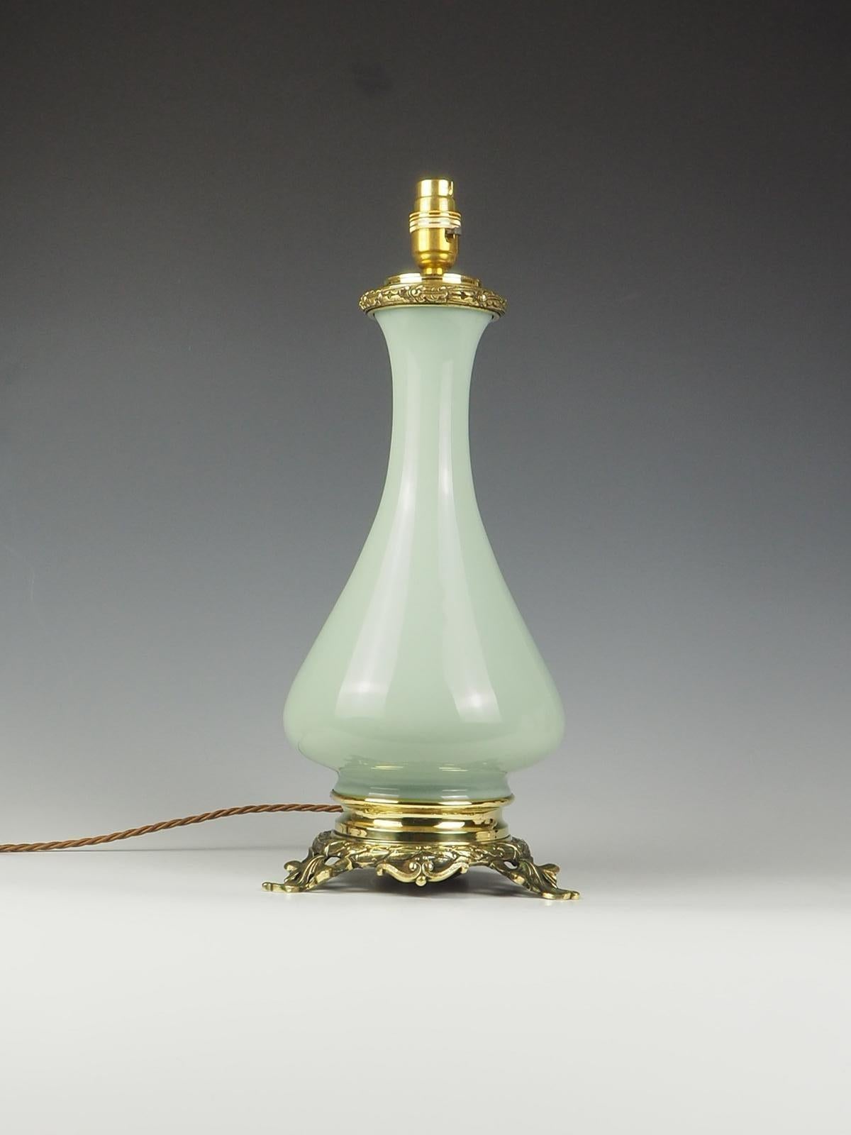 Exquisite Antique French Opaline Celadon and Bronze Table Lamp showcases a perfect blend of timeless elegance and functionality. Originally designed as an oil lamp, it has been thoughtfully converted to electric, ensuring convenience without