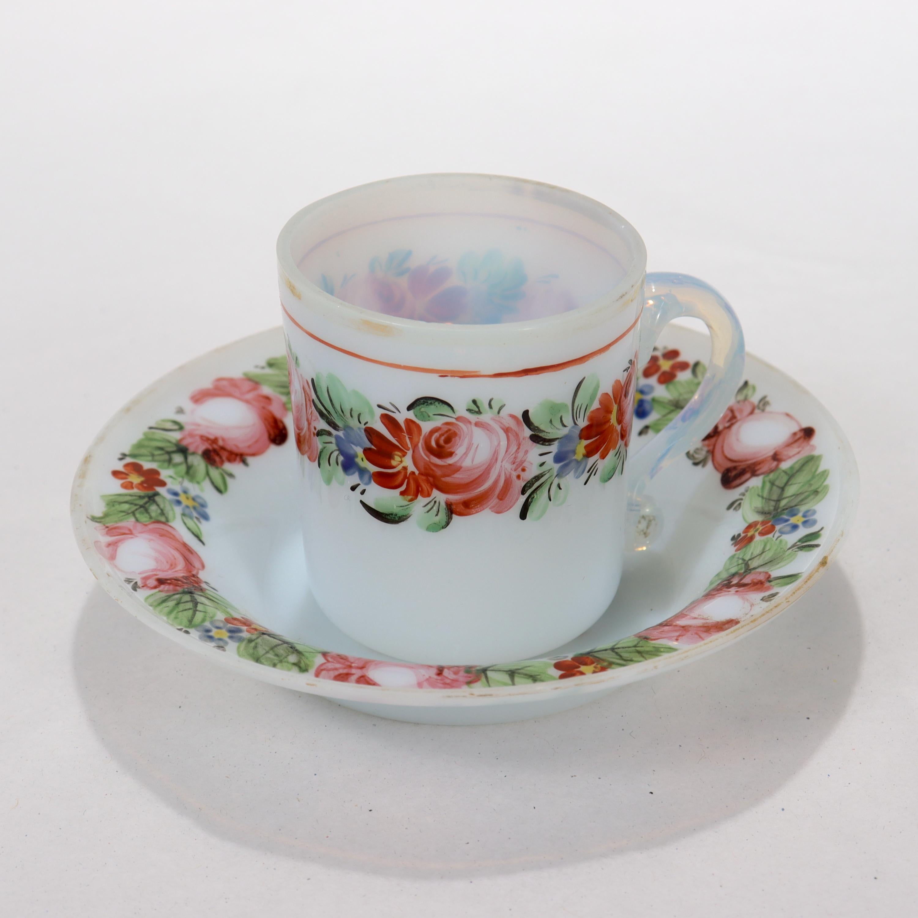 Eine feine antike weiße Opal- oder Opalglas-Tasse mit Untertasse.

Mit handgemalten Blumengirlanden auf dem Körper der Tasse und dem Rand der Untertasse sowie Spuren der ursprünglichen Vergoldung.

Einfach ein wunderbares frühes Tassen- und