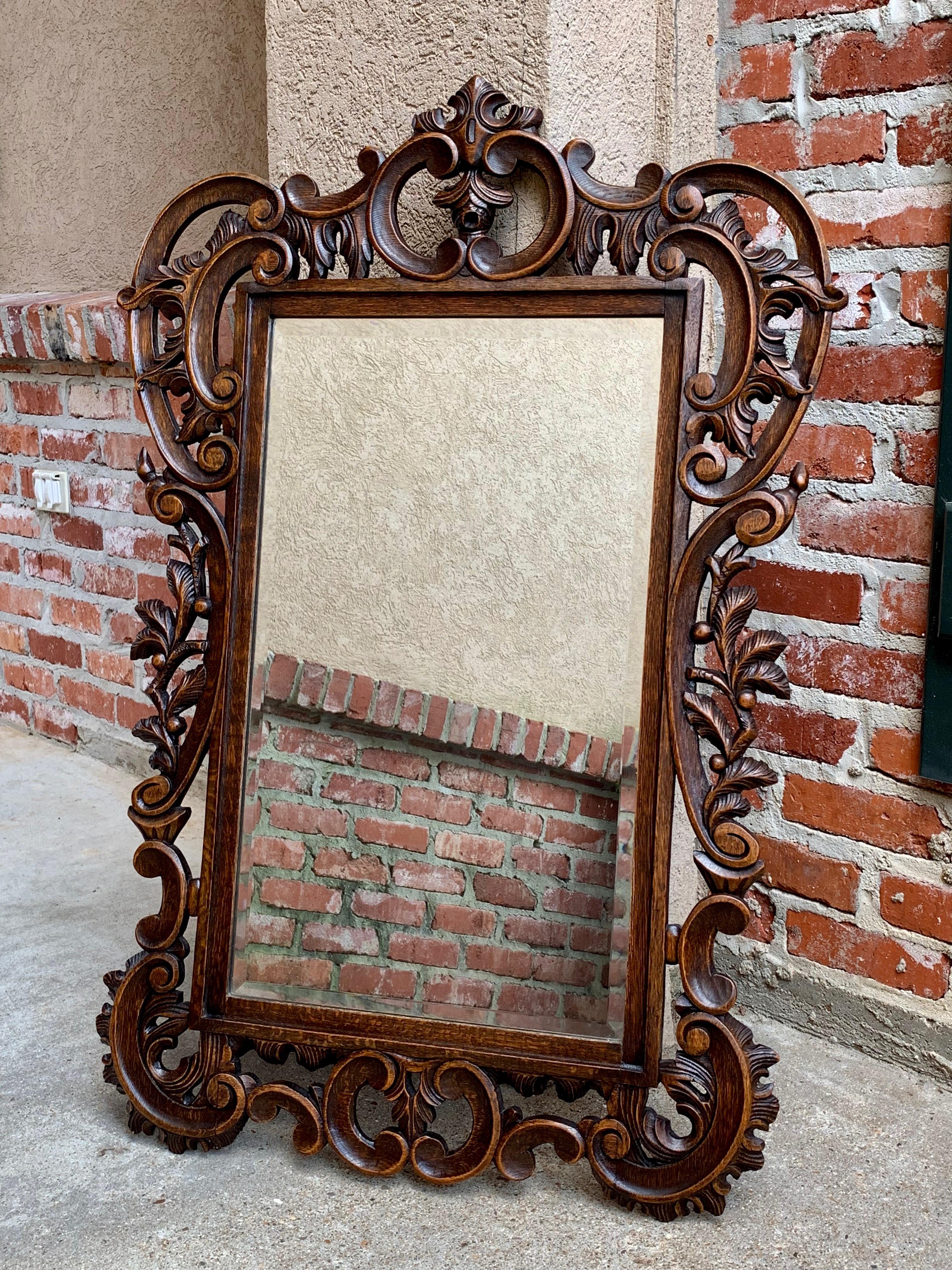 Direct from France, a fabulous antique French oak frame wall mirror with exquisite hand carved details. From the top of the huge open carved crown, down the sides completely embellished with scrolls and foliage, all the way to the open carved