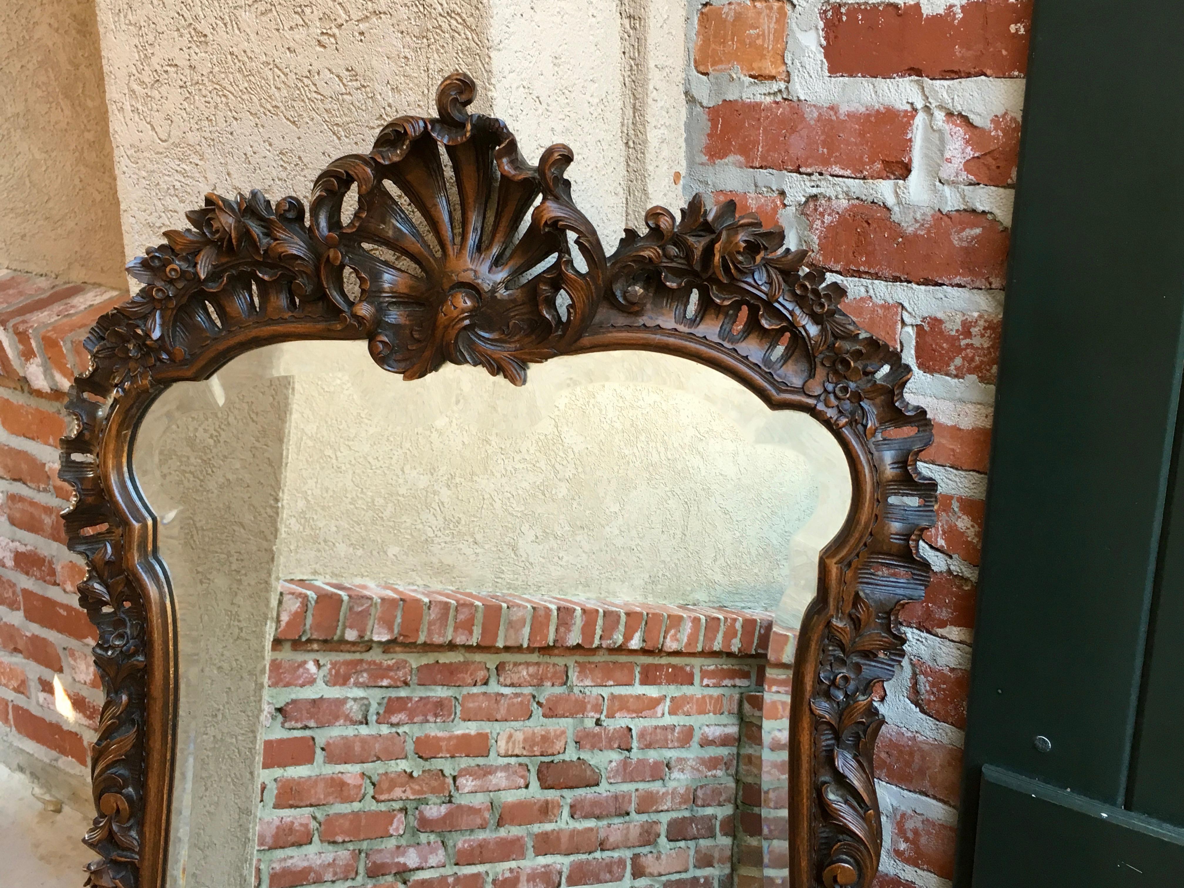 Direct from France, a beautiful antique carved oak frame wall mirror with exquisite hand carved details. From the top of the huge open carved crown, down the sides completely embellished with scrolls and foliage, all the way to the open carved