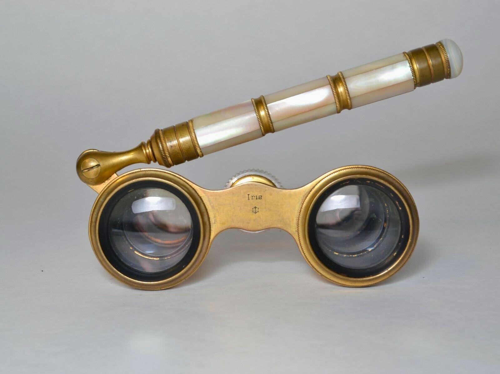 An antique pair of French opera glasses with a pivoting handle by Iris of Paris. The small and elegant telescoping binoculars were crafted during the late 19th century at the height of the Belle Époque in gilt metal with beaded bands and exquisite