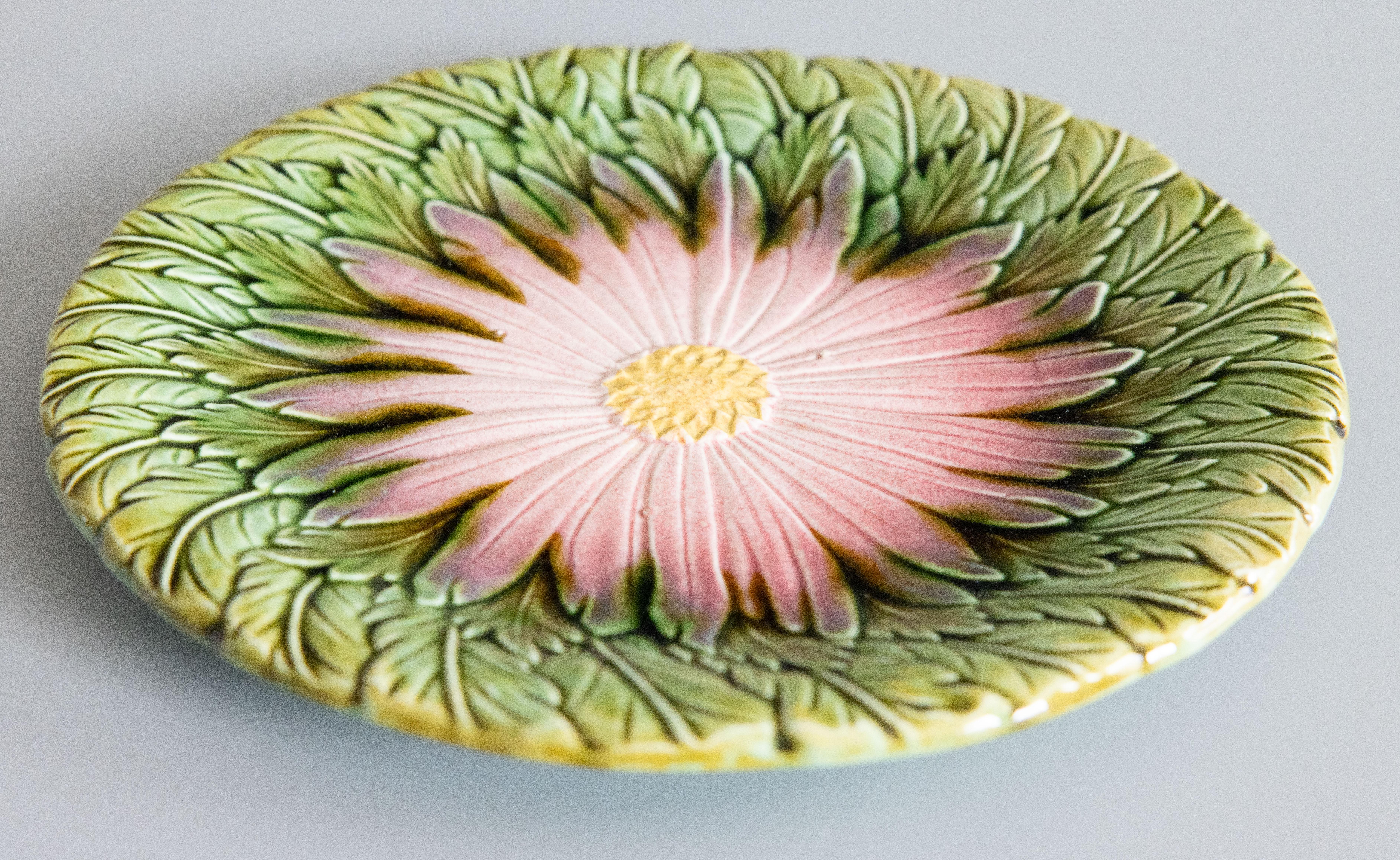 Ravissante assiette à marguerite en majolique française du XIXe siècle, attribuée à Orchies, vers 1890. Non marqué. Cette magnifique assiette est ornée d'une marguerite rose tendre peinte à la main sur un fond de feuilles vertes. Elle s'affiche