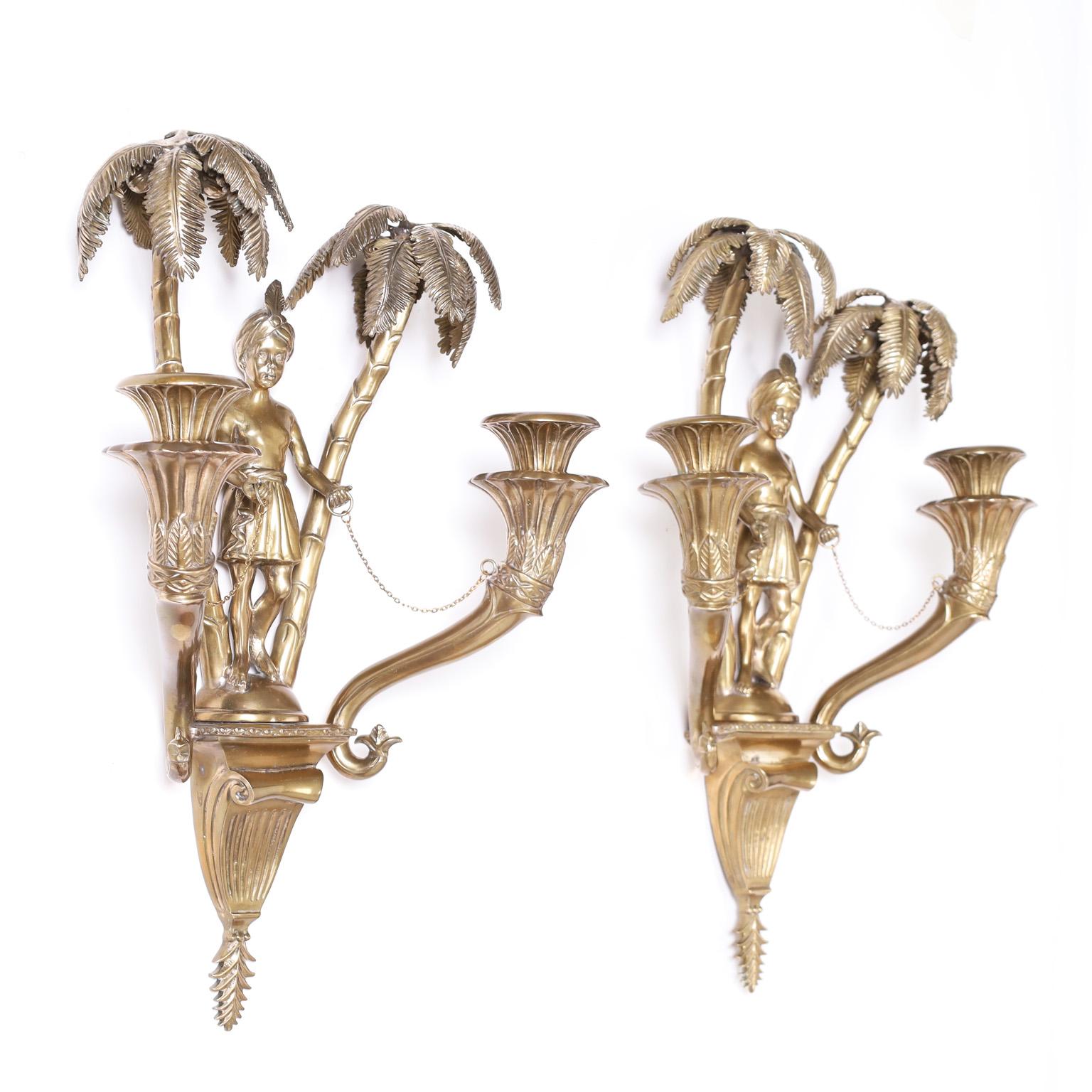 Intriguing pair of antique French Orientalist two light wall sconces with a polished bronze finish, featuring a figure with a turban under a pair of palm trees.