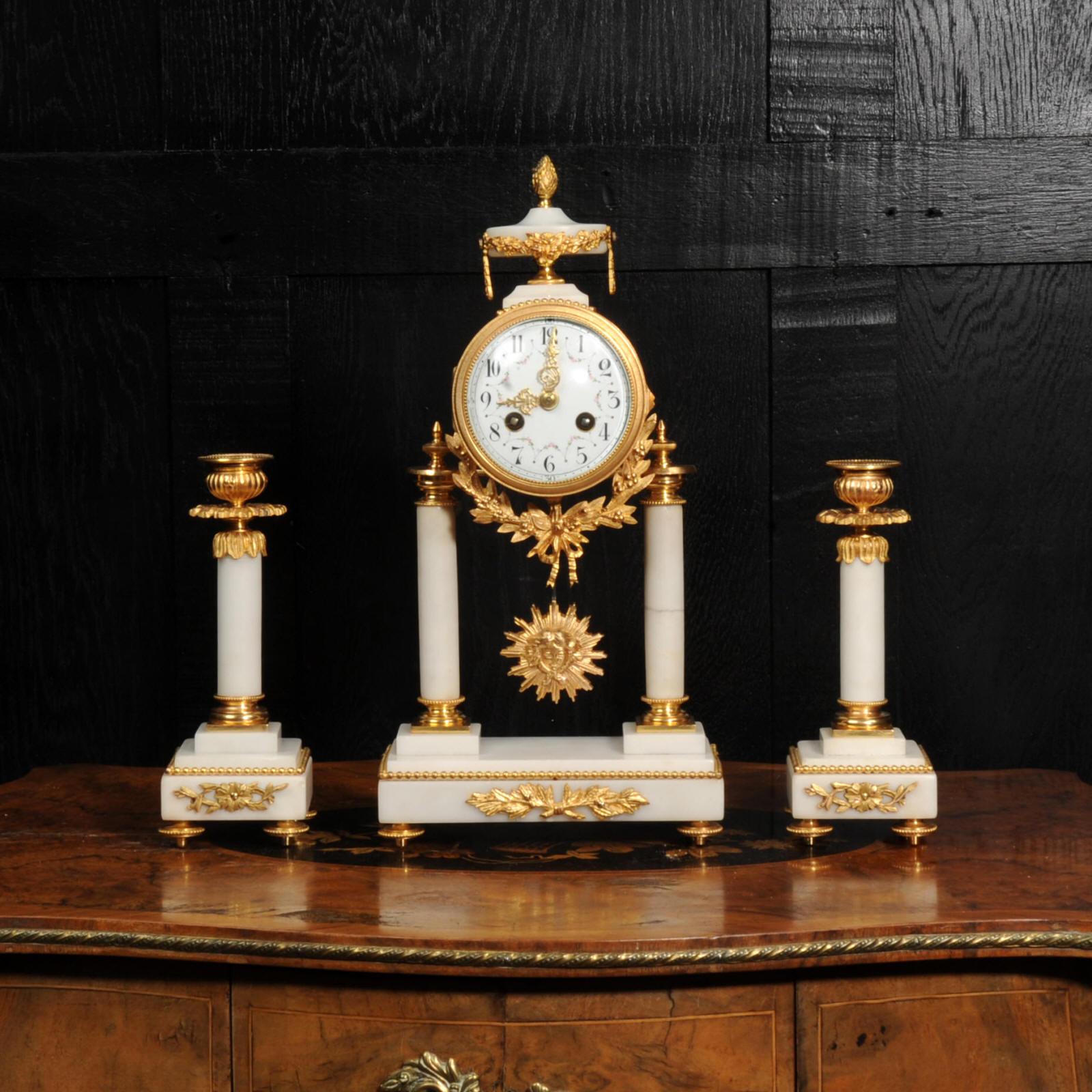 A beautiful original antique French portico clock by Vincenti. It is made of white marble mounted with ormolu (finely gilded bronze). The movement is held aloft on two marble pillars with the ormolu sunburst pendulum swinging gently below. A