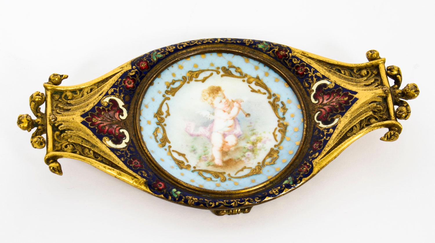 A really beautiful French ormolu, champlevé enamel and Sèvres Porcelain pin tray, circa 1880 in date.

The ormolu and champleve border is set with a charming hand painted winged cherub on a bleu celeste ground with gilt highlights. 

Add this