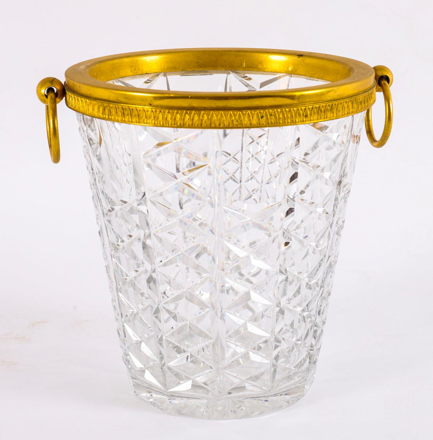 This is a fine antique French ormolu and cut crystal wine cooler/ ice bucket Circa 1900 in date.

It features an ormolu rim with a pair of ring handles decorated with leaf fluting above a thick cut diamond pattern cut crystal body.

It is a fabulous