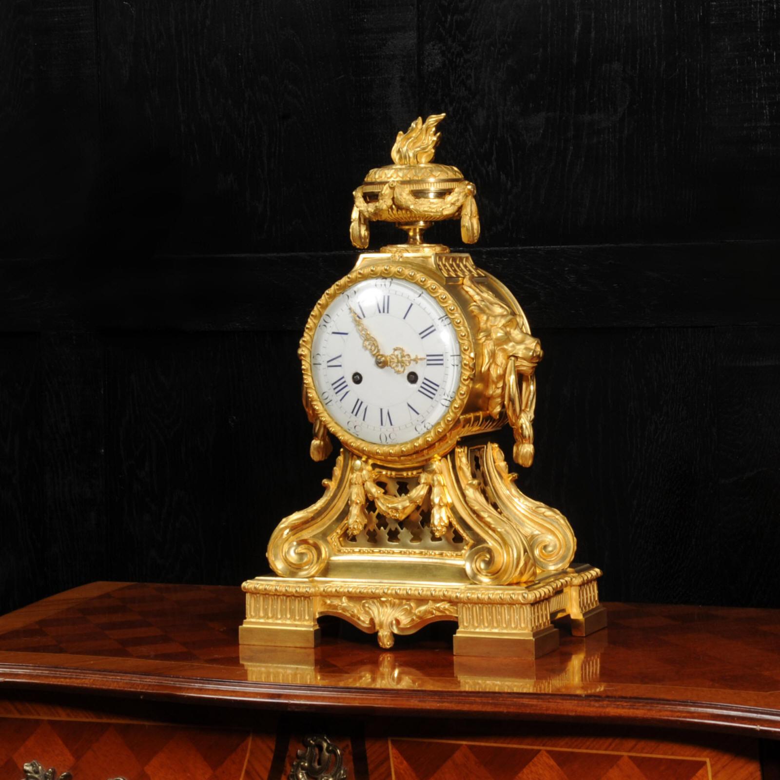 A fine and early original antique French drum head clock, circa 1860. Beautifully made in finely gilded bronze, It is of Neoclassical design with lions masks, scrolling acanthus supports and a classical urn to the top with flame finial. Pierced