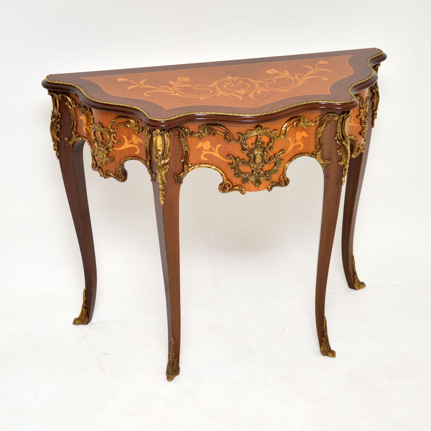 An absolutely stunning console table in the antique French style, this dates from circa 1930s period.

It is of amazing quality, with fine quality gilt bronze mounts around the frieze, top edge and feet. This is made from king wood and mahogany,
