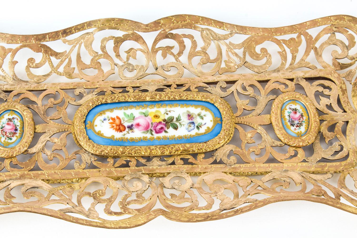 This is a wonderful antique French ormolu pen tray, mounted with three Bleu Celeste Sevres porcelain plaques that have been beautifully gilded and painted with floral bouquets, C 1870 in date.

Of rectangular form with and centred with a large