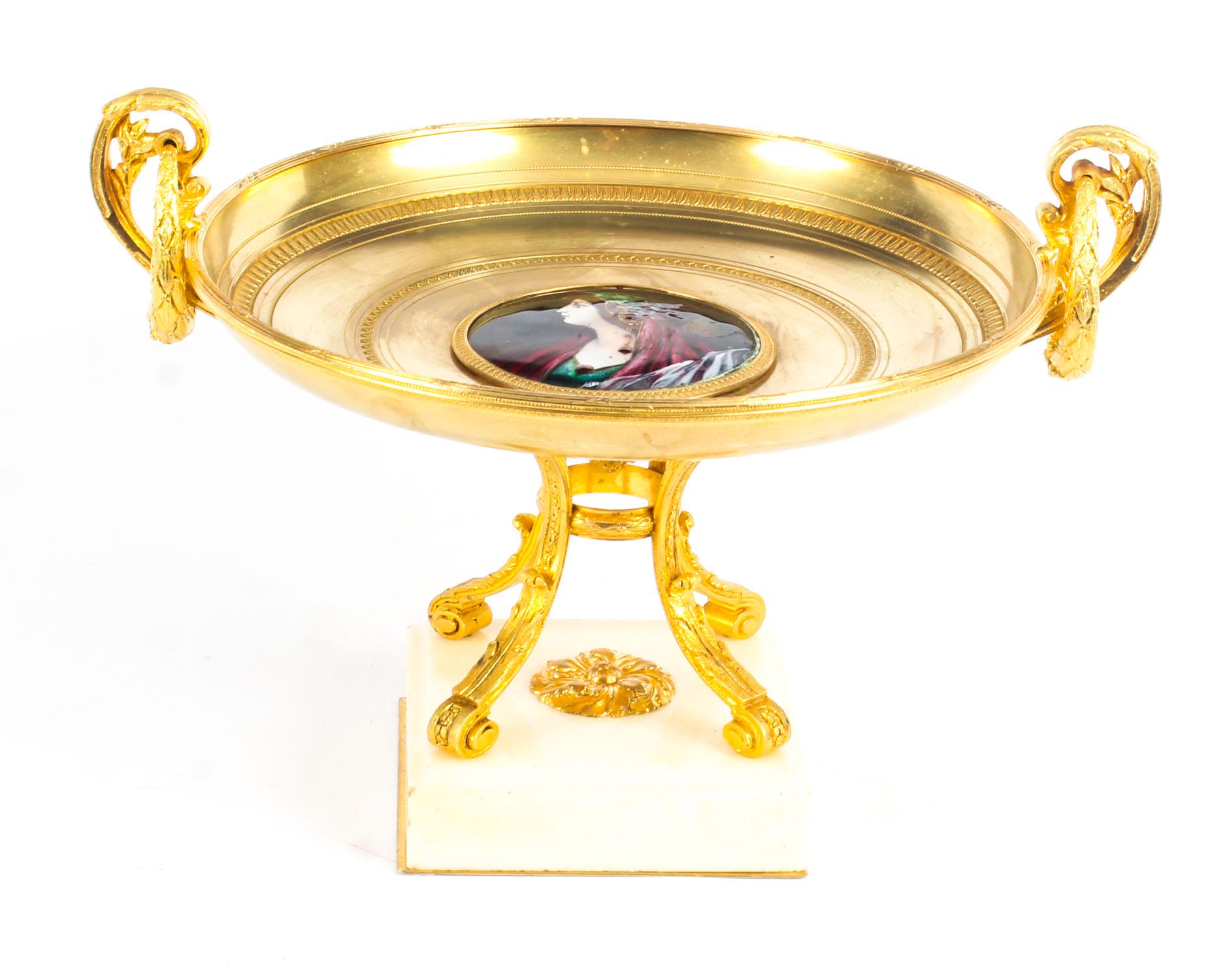 This is an impressive and highly decorative French ormolu tazza, mid-19th century in date.

It features twin handles to either side and the centre is inset with a beautiful Limoges enamel plaque depicting a lady in Renaissance clothing. It is