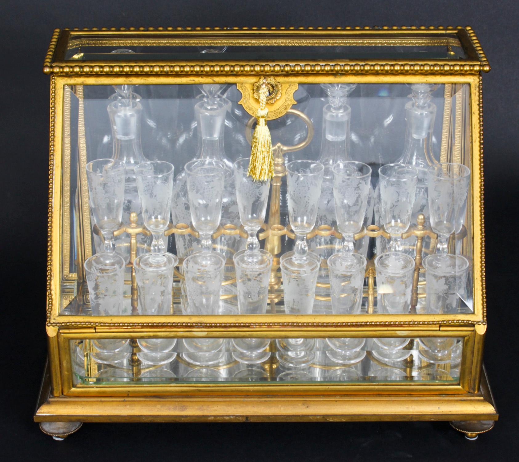 This is an exquisite antique French Napoleon III ormolu and glass Cave a Liqueur, or tantalus, circa 1850 in date. 
 
The Cave a Liqueur features a gilt bronze case with sloping hinged door having a beaded edge and five bevelled glass panels