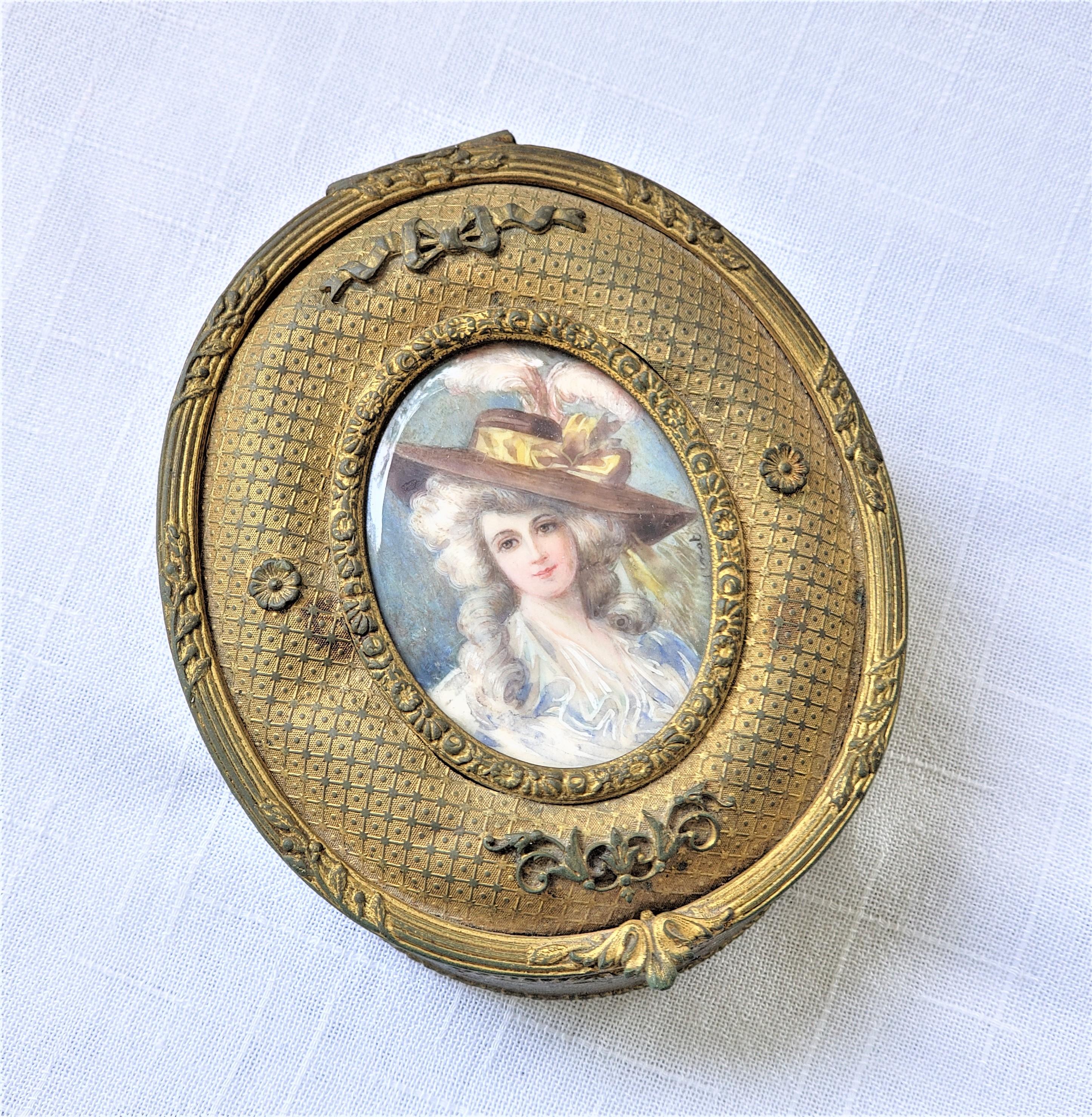 This small jewelry or decorative box has no maker's signature, but presumed to have originated from France and date to approximately 1900 and done in a Renaissance Revival style. The oval shaped box is composed of metal with a gilt finish and