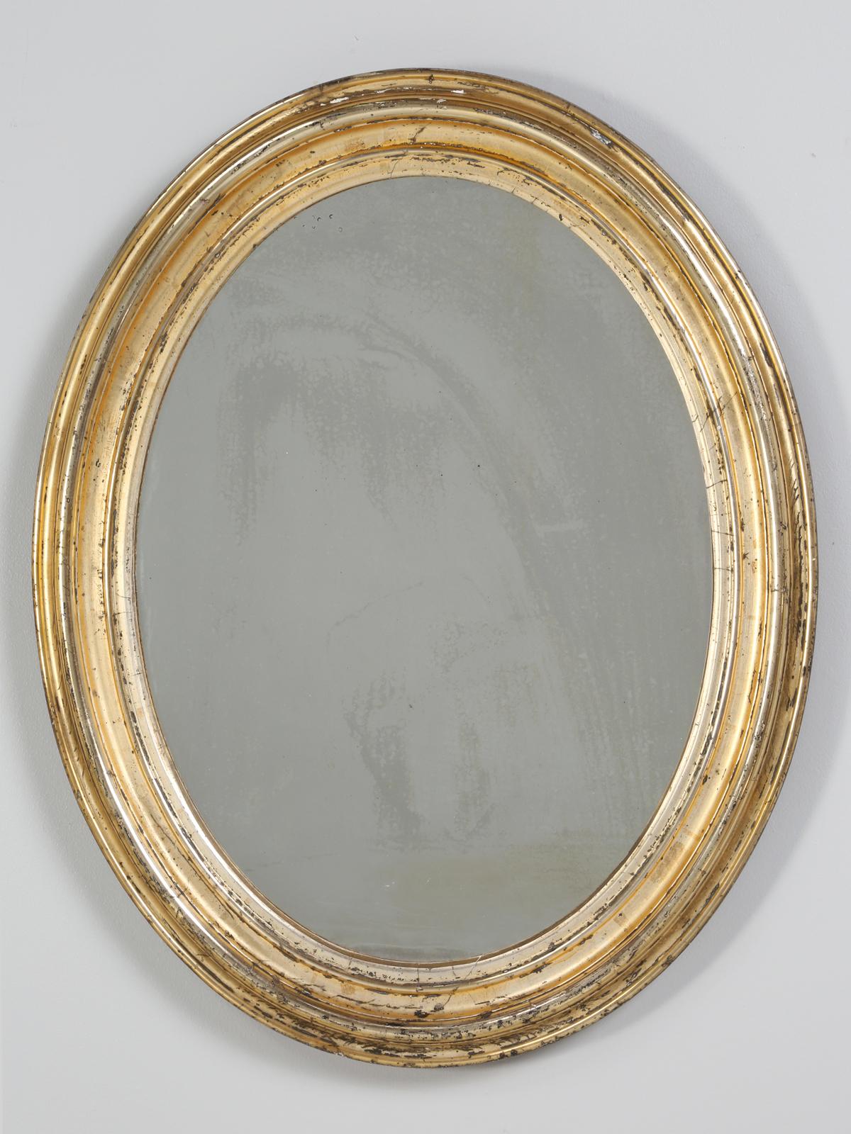 Antique French gilt oval mirror and unusual that it still retains the original 24-karat water gilding finish. Most of the French antique oval mirrors we see, have been touched up, with what looks like the old fashion gold radiator paint. This