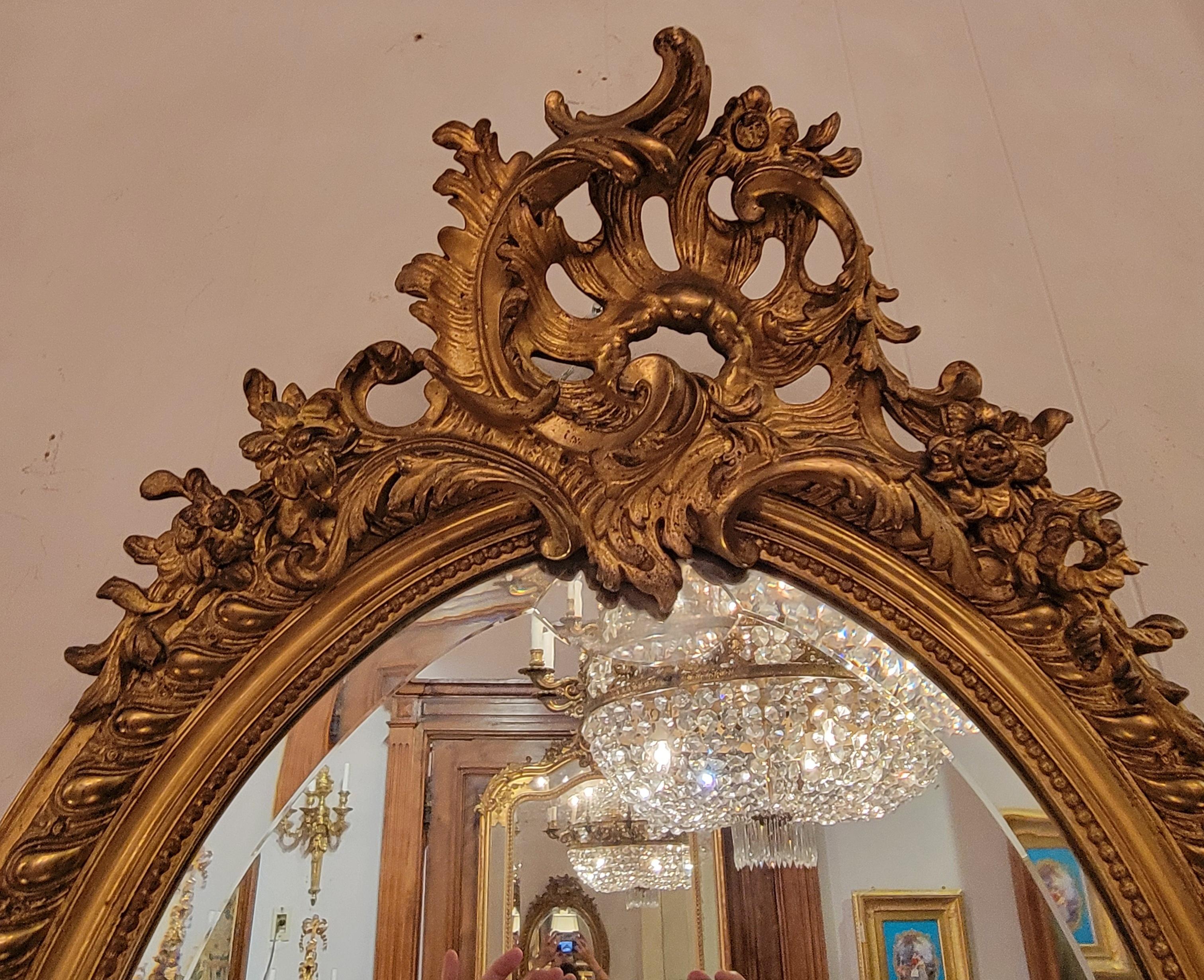 Miroir français ancien de forme ovale à encadrement de feuilles d'or avec biseautage, Circa 1895.
