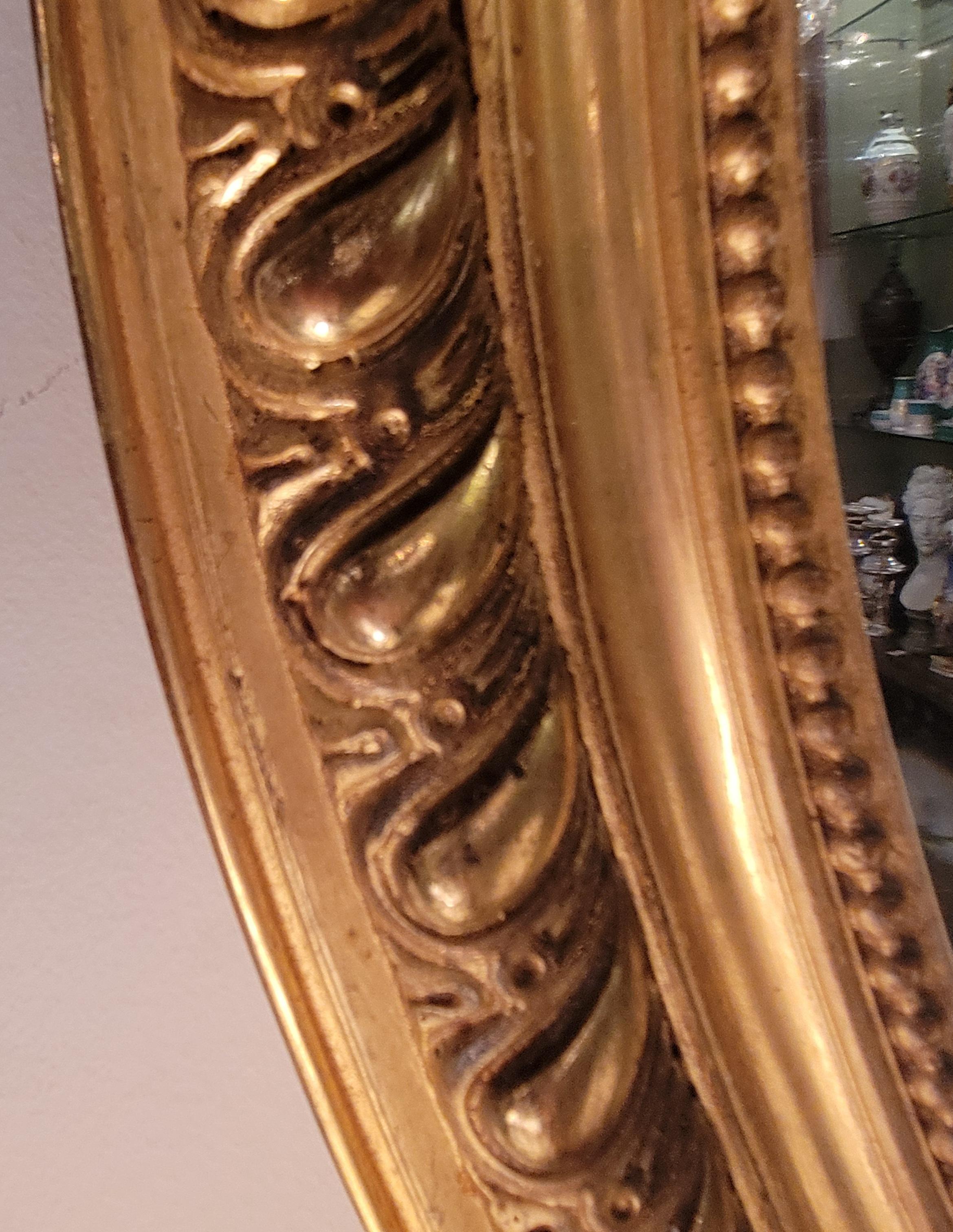 Biseauté Ancien miroir français de forme ovale encadré de feuilles d'or avec perlage, vers 1895. en vente