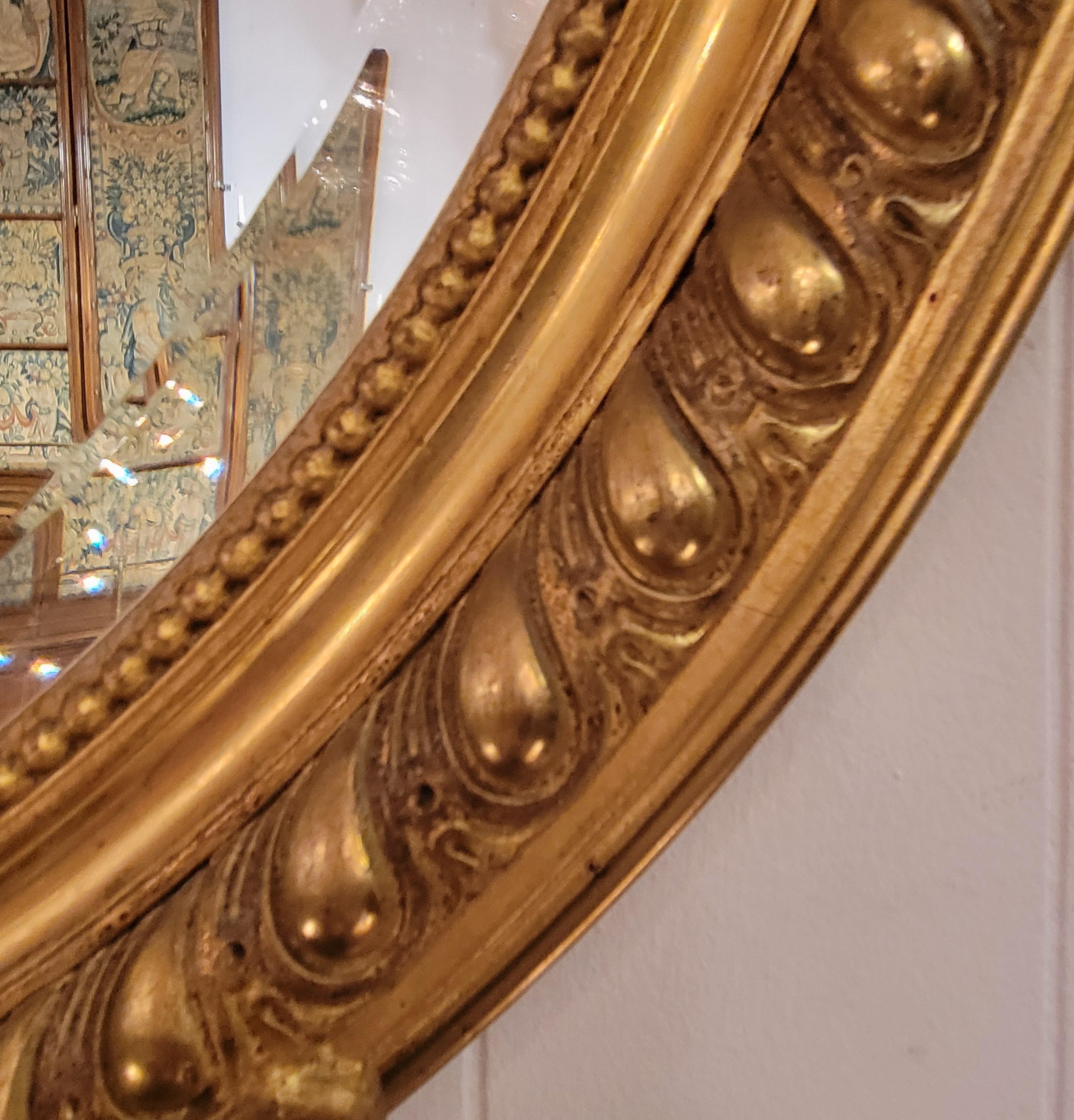 XIXe siècle Ancien miroir français de forme ovale encadré de feuilles d'or avec perlage, vers 1895. en vente