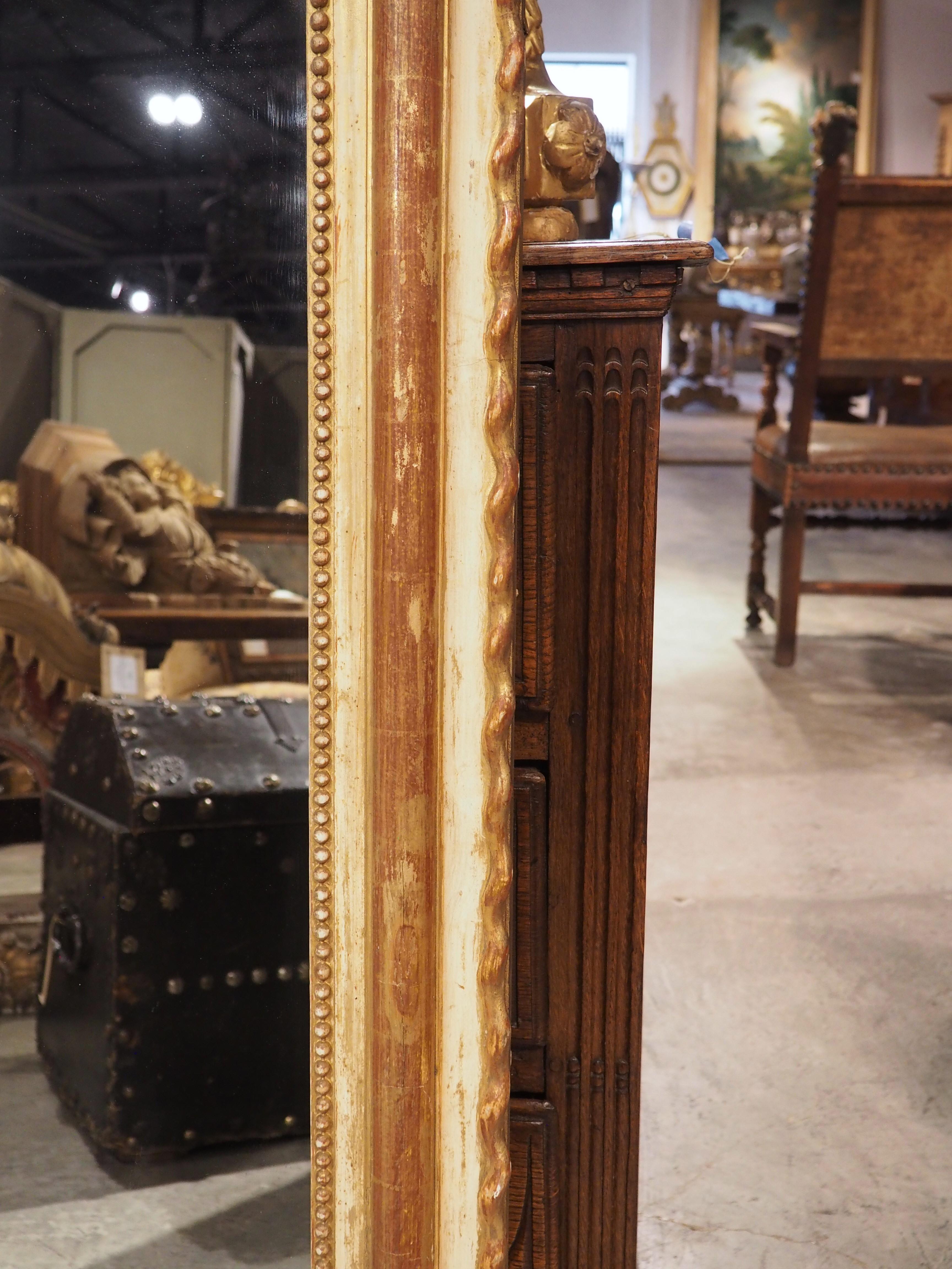 An imaginative rendering of a timeless piece of furniture, this painted and gilt Louis Philippe-style mirror has added character thanks to the hand-carved scalloped edges. Louis Philippe mirrors typically have clean lines and subtle embellishments