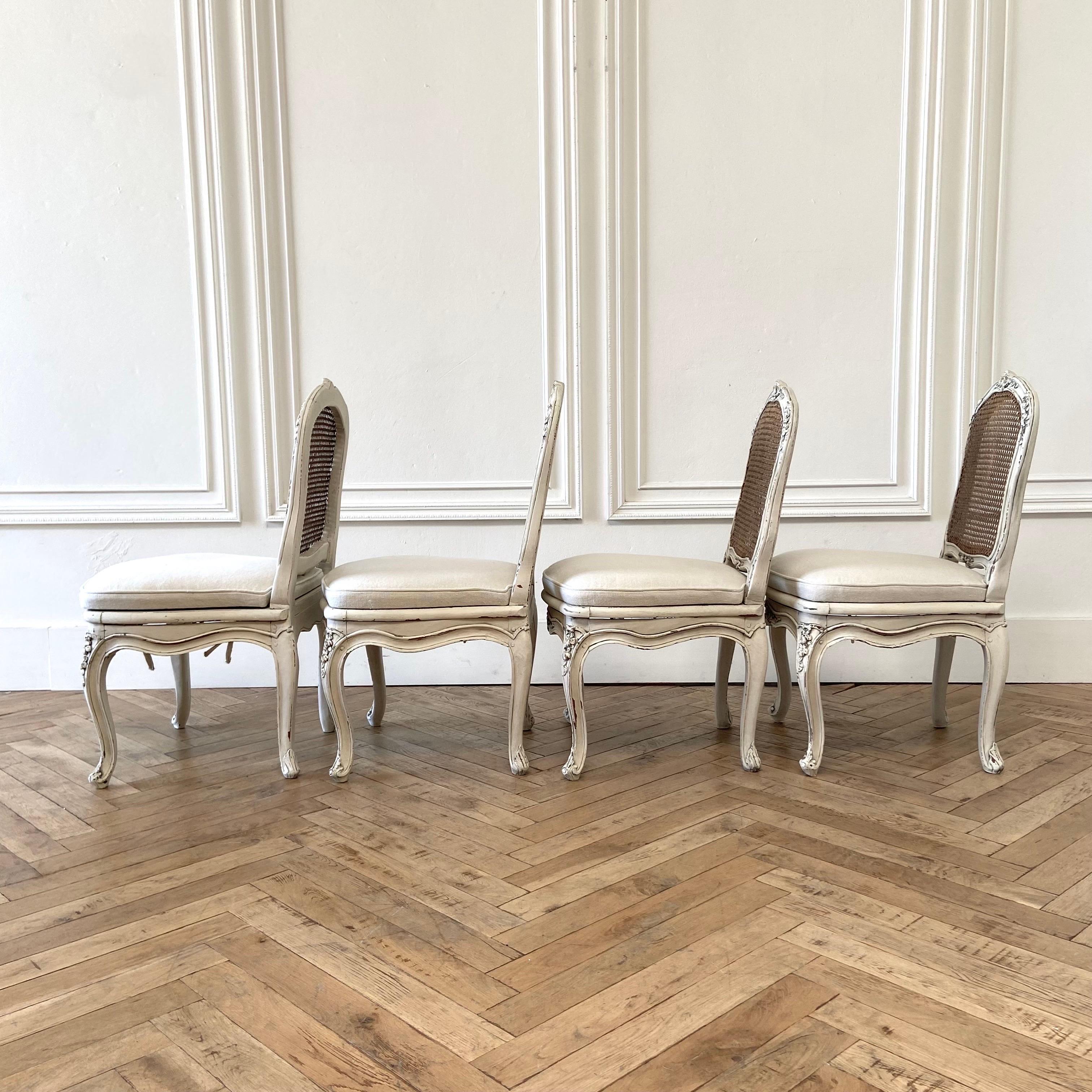 Set of 4 Antique French cane back chairs painted in a soft oyster white finish, with subtle distressed edges, and finished with an antique patina.
SIZE: 
Cane is natural finish, with beautiful patina.
Newly constructed seats from an HR foam,