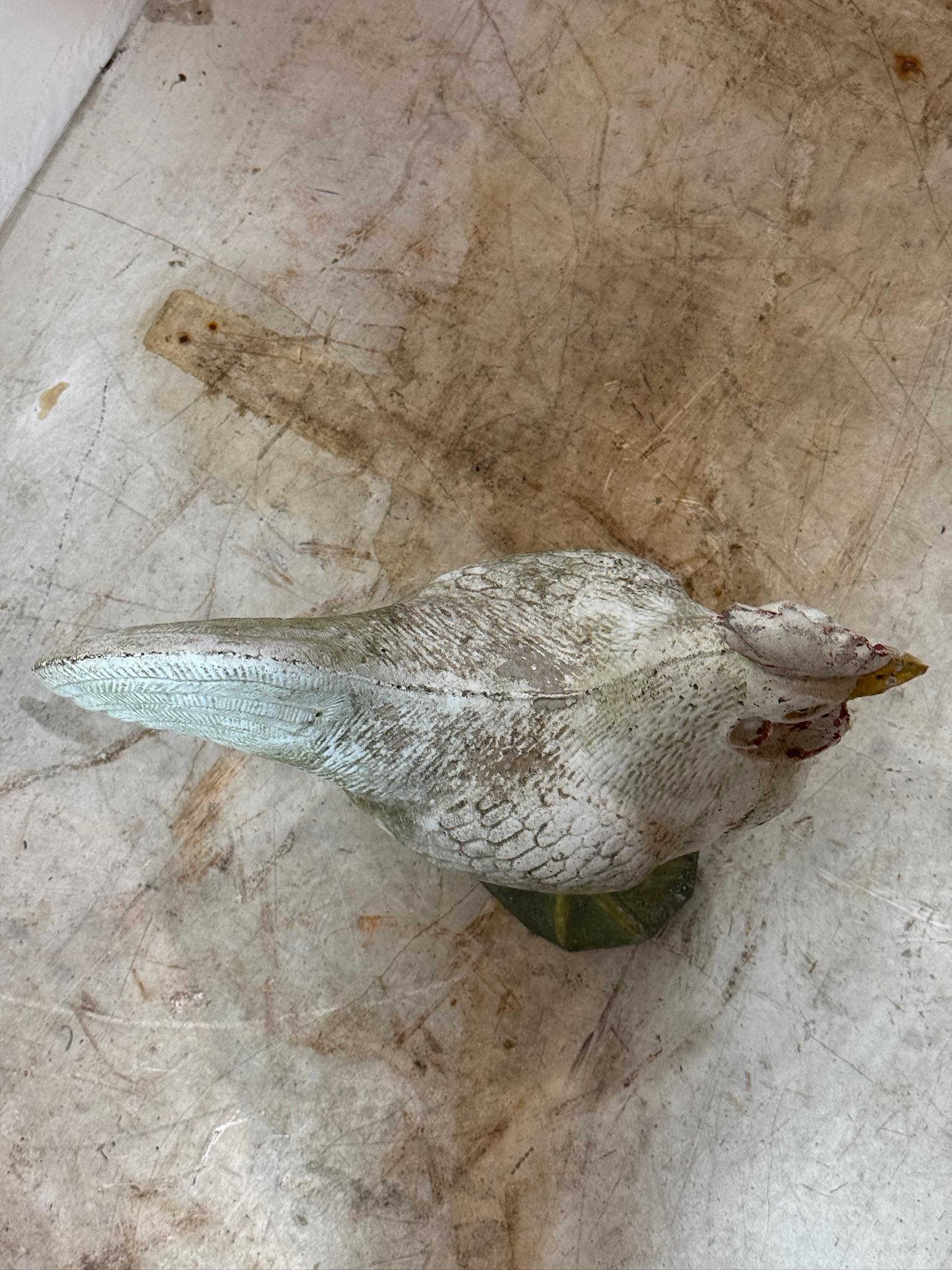 Esta encantadora estatua antigua francesa de gallo de hormigón pintado es una llamativa pieza de decoración vintage de granja. Fabricada en hormigón fundido macizo, presenta intrincados detalles en forma de pluma y una pátina desgastada que aumenta