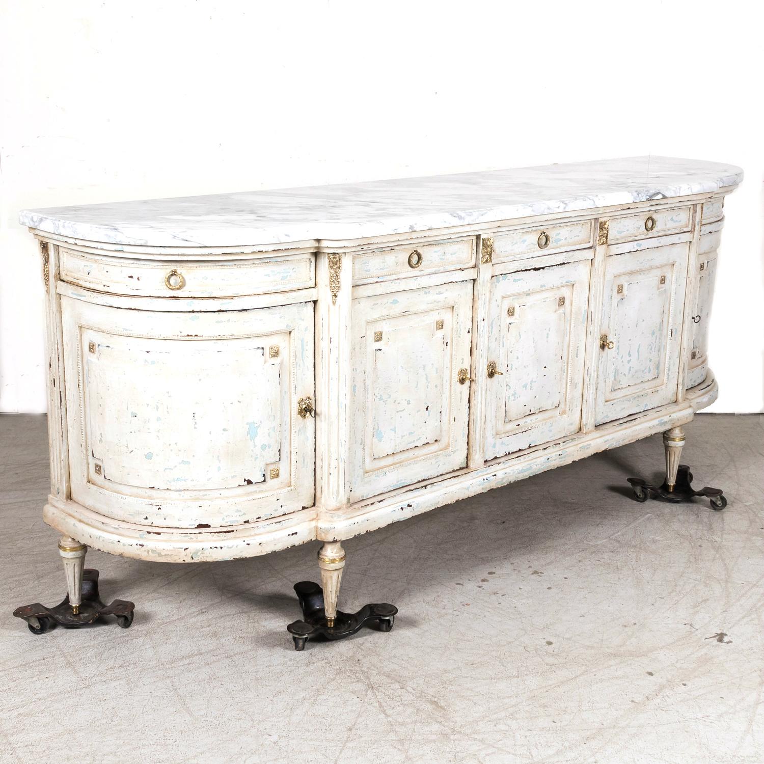 An impressive early 20th century antique French Louis XVI style five drawer, five door demilune enfilade buffet handcrafted of mahogany in Paris, circa 1920s. Having a beautiful painted finish, the original thick, moulded and beveled Cararra marble