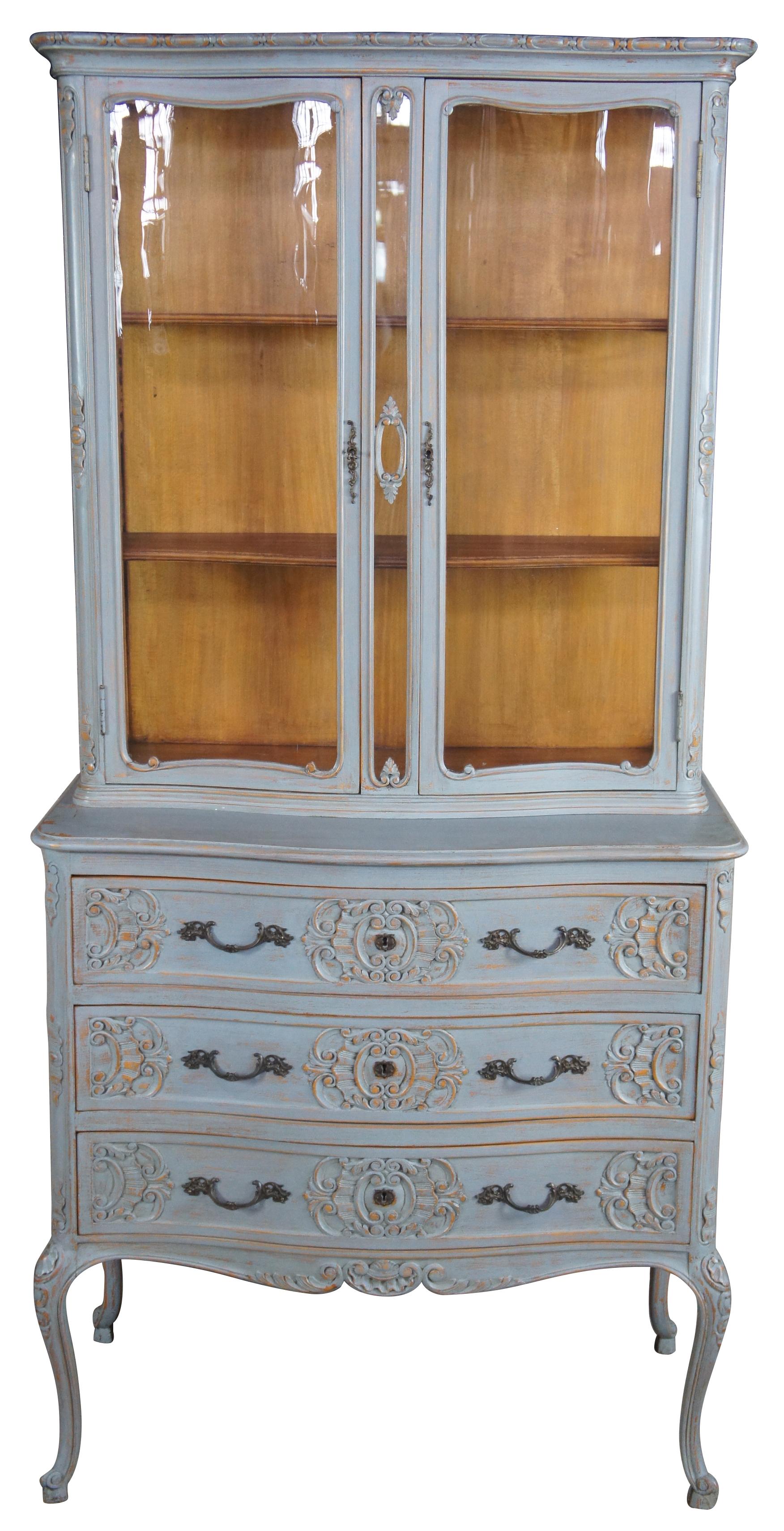Early 20th century French curio cabinet. Made from oak. Features three scalloped and carved drawers, cabriole legs and a glass covered hutch with two shelves. Painted grey with metal hardware.
   