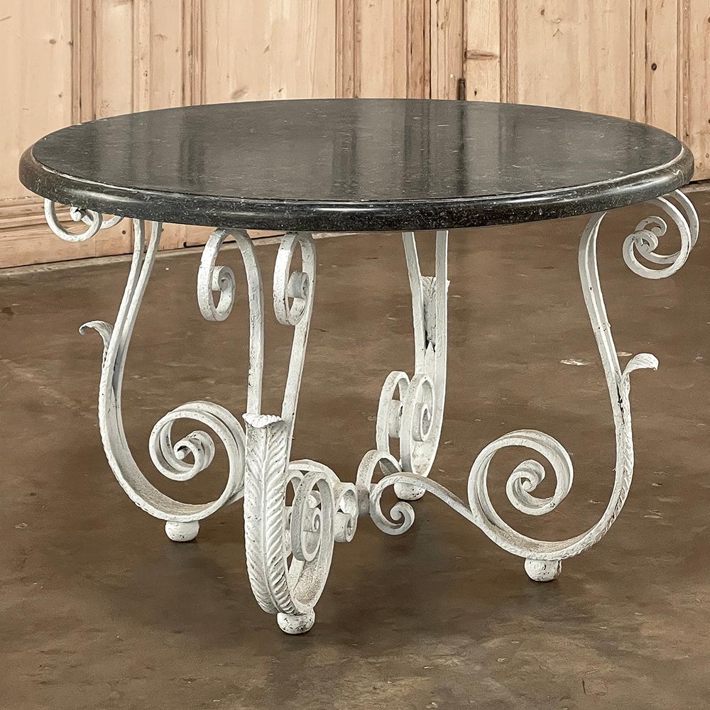 Antique French Painted Wrought Iron Round Coffee Table with Black Marble was crafted by an obviously talented and inspired blacksmith, with four bold, elegant double scrolls created to form the legs, attached with a hoop above to support the top,