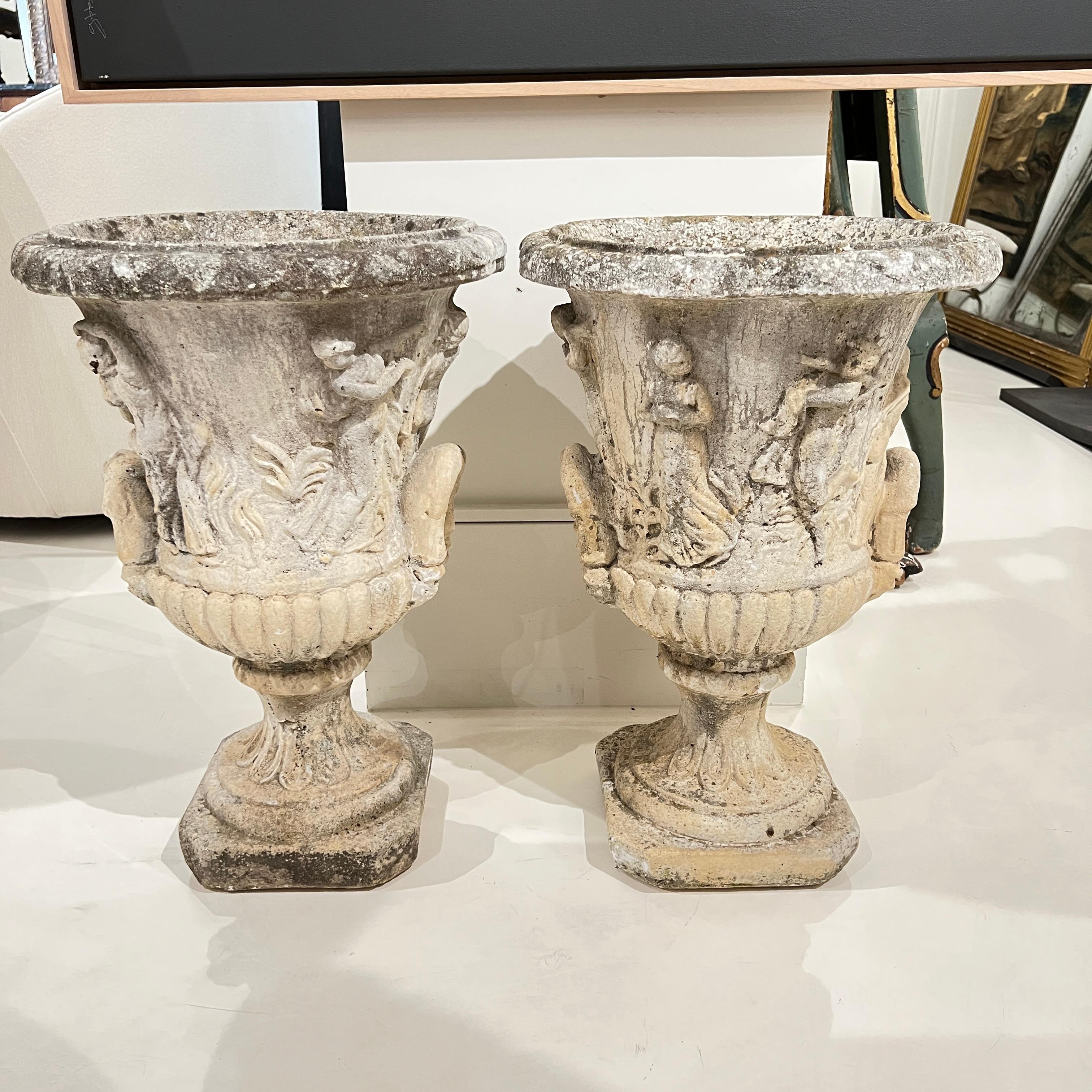 Une paire de jardinières en béton robustes et élégantes, ornées de délicats reliefs néoclassiques, avec des motifs tels que des guirlandes et des urnes - parfaites pour ajouter un charme architectural et une élégance intemporelle au jardin ou aux