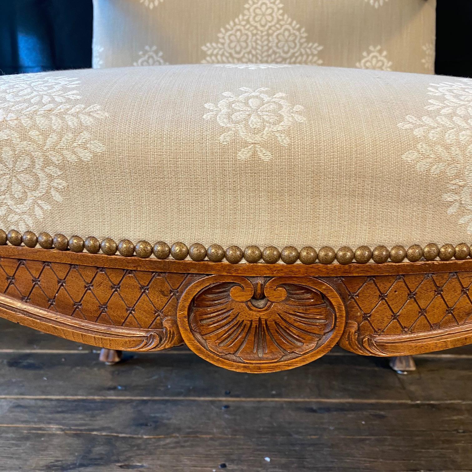 Elegant and charming pair of late 19th century carved armchairs, fauteuils or lounge chairs featuring newly upholstered walnut frames. The large frames are decorated in the French Provincial or Louis XV taste with shell rocaille motifs on the apron.
