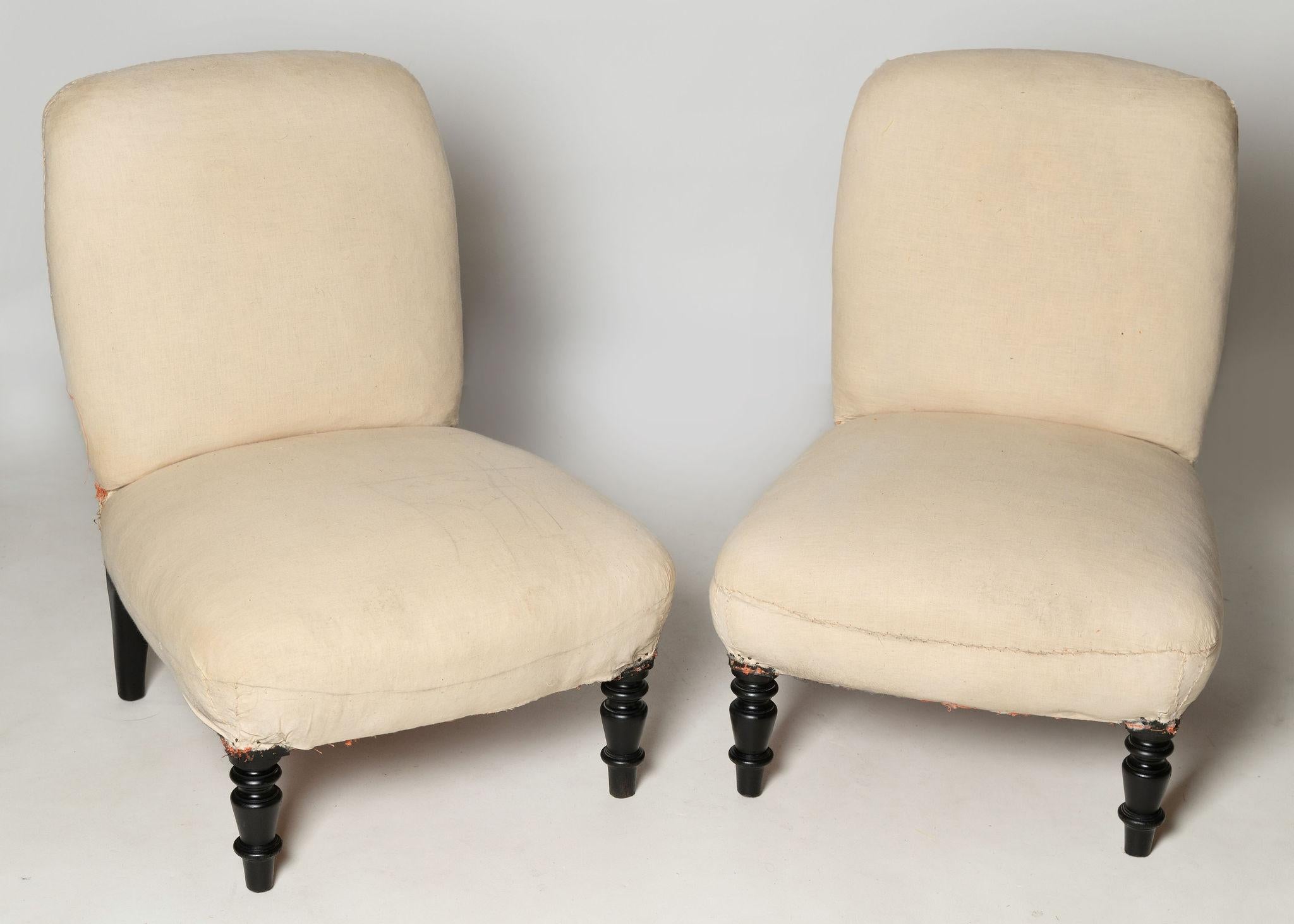 Unusual shape pair of antique French slipper chairs, ideal fireside, bedroom or occasional chairs. Seat depth 18 inches. Floor to seat 12.5 inches. Ready for upholstery, structurally sound. 

Width: 21 
