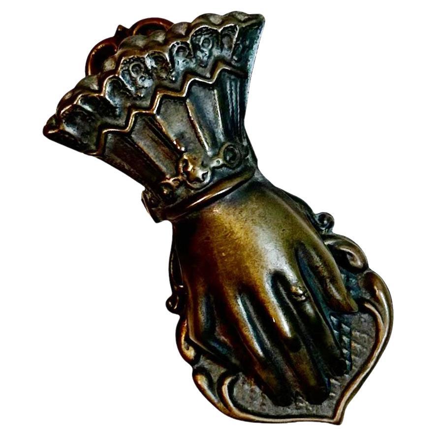 A very whimsical antique French brass paper clip in the form of a hand.