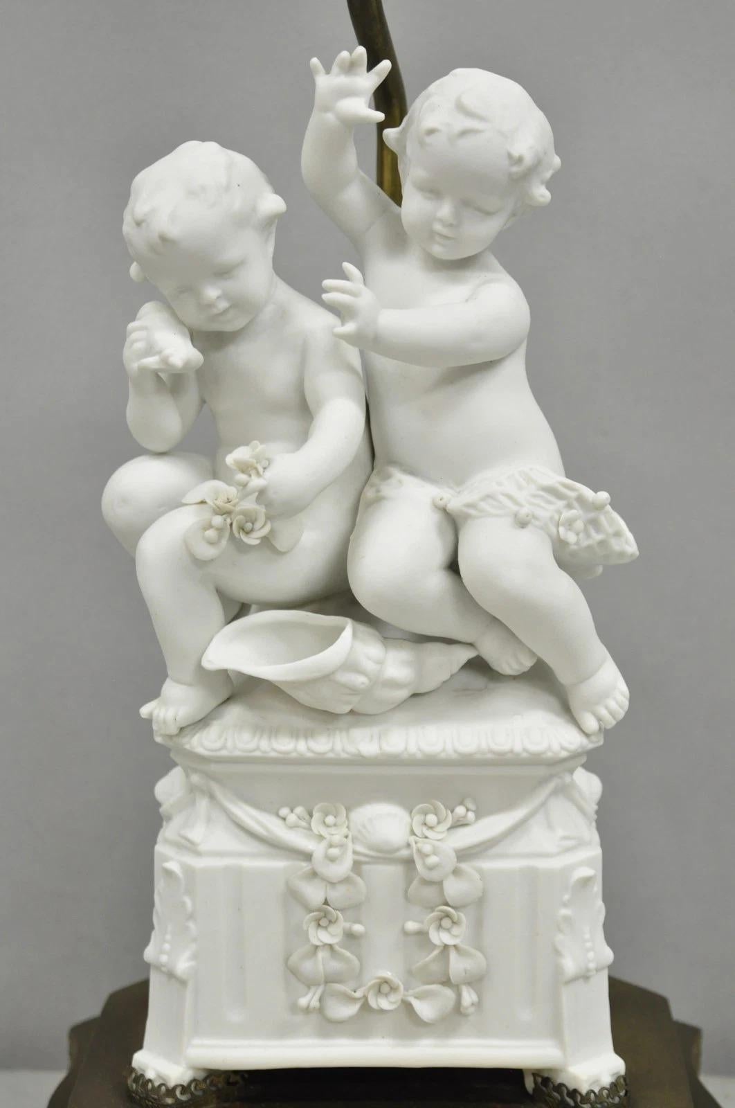 Antique French Parian Bisque Porcelain White Double Cherub & Shell Table Lamp on Figured Brass Base. Circa Early 20th Century. Measurements: 29