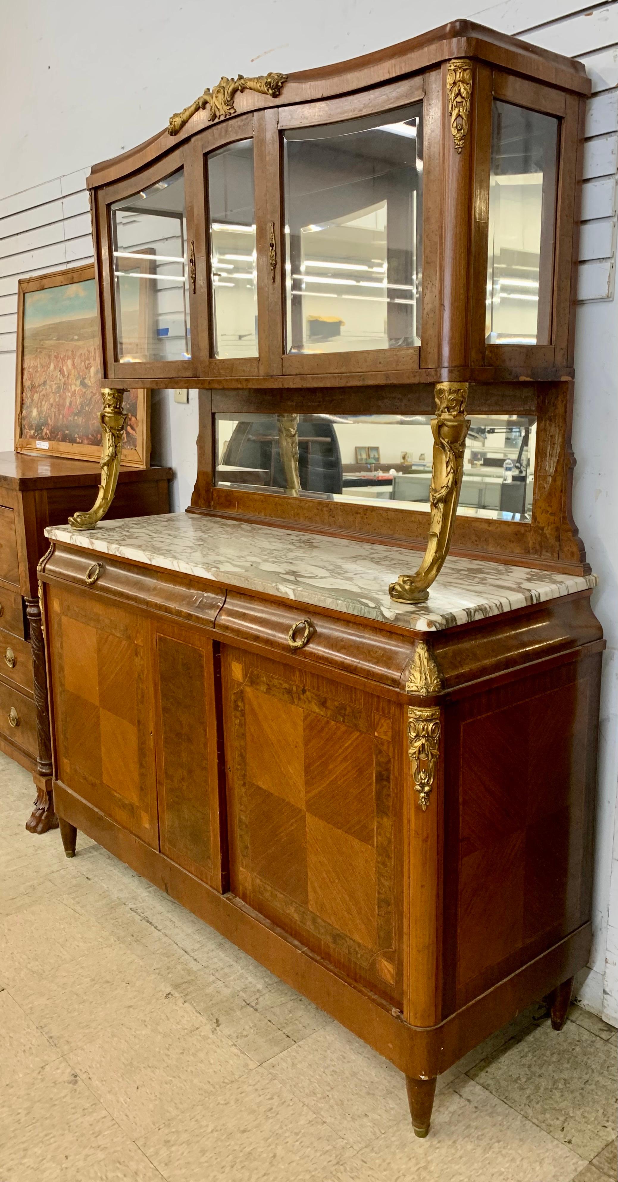 Magnificent antique French two tiered display cabinet breakfront with marble top credenza and bronze ormolu mounts and supports. The piece consists of a vitrine mounted on to a bottom cabinet which features parquetry on the two front doors that open