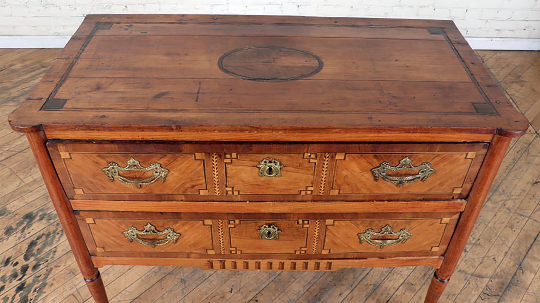 Antique French parquetry commode in the neoclassic manner- featuring two drawers on elegantly tapered legs.