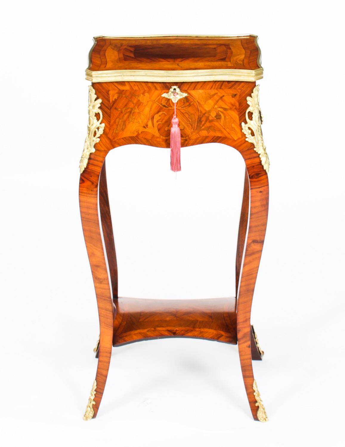 This is a beautiful antique French Louis Revival parquetry and marquetry ormolu mounted serpentine side table / teapoy kettle stand, circa 1850 in date.

The ormolu banded top has a Horne's patent hinge with beautiful banded parquetry enclosing a