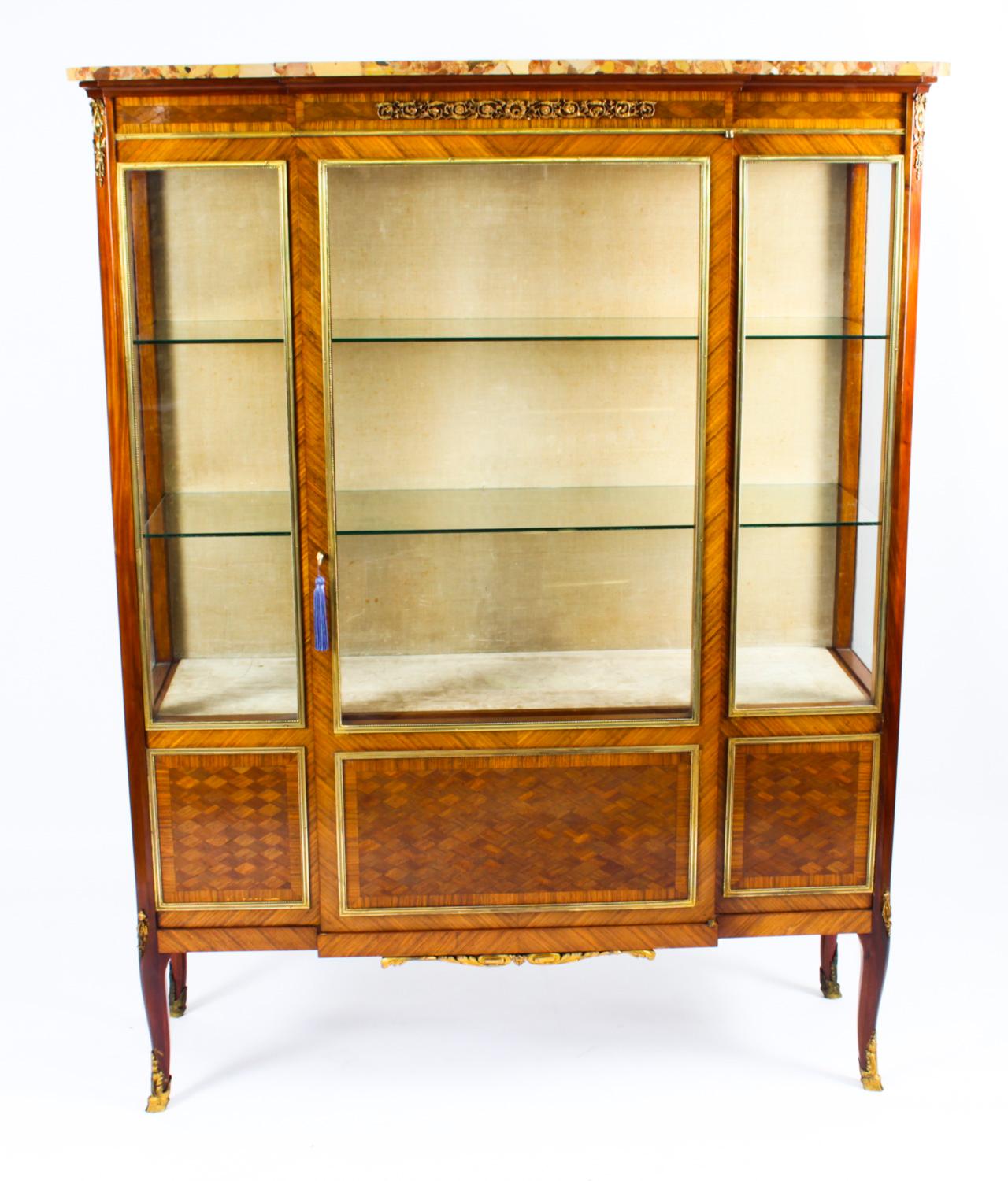 This is a beautiful antique French Louis Revival parquetry and ormolu mounted breakront vitrine, circa 1860 in date.
 
This beautiful cabinet has exquisite parquetry and crossbanded decoration with gilded bronze ormolu mounts. The shaped breccia