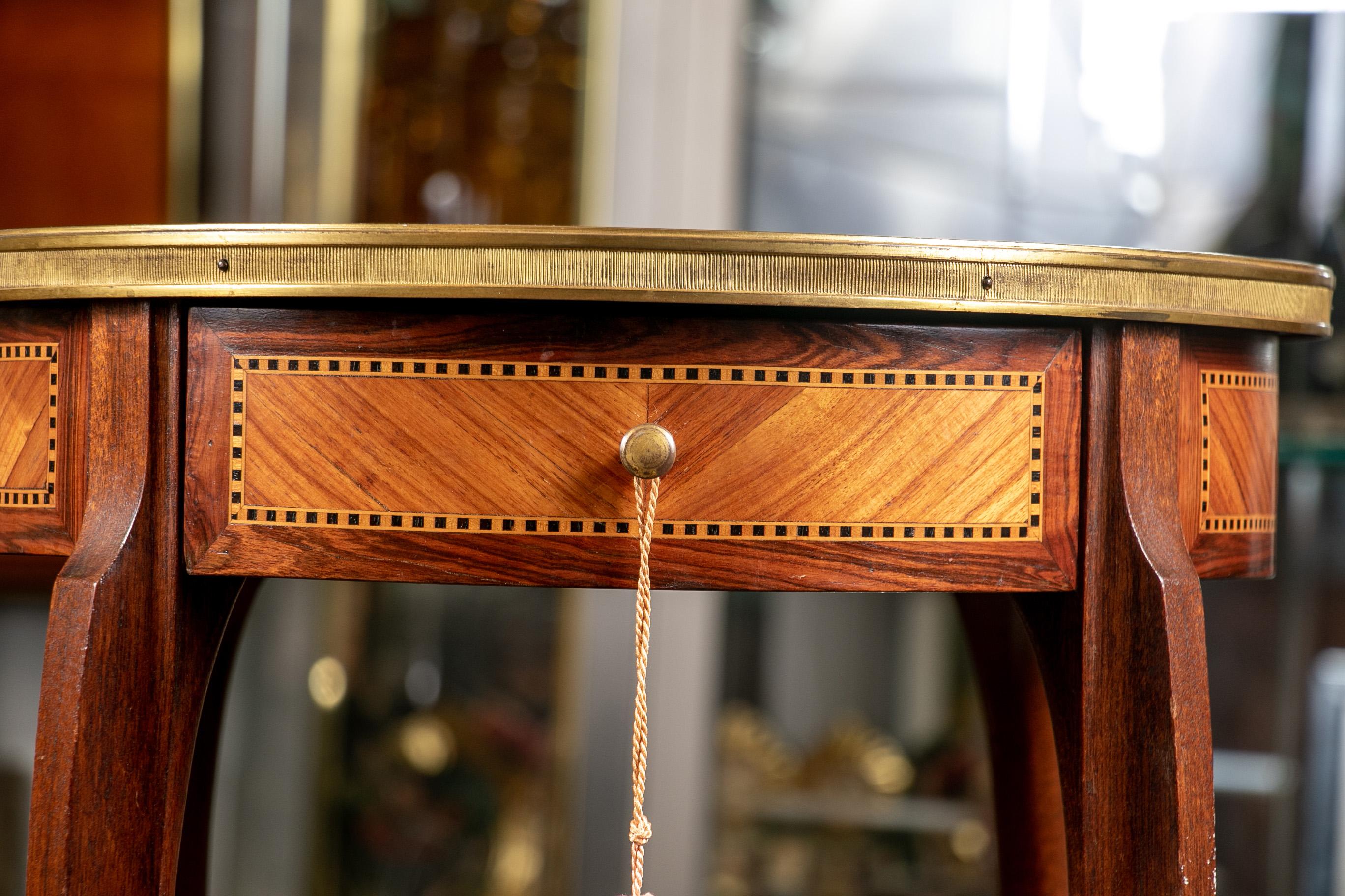 Antique French parquetry round tiered stand, mahogany banded top tier with satinwood sunburst pattern and checked string inlay, the parquetry frieze with checked string inlay and one frieze drawer. The lower tier with sunburst pattern. Brass banded